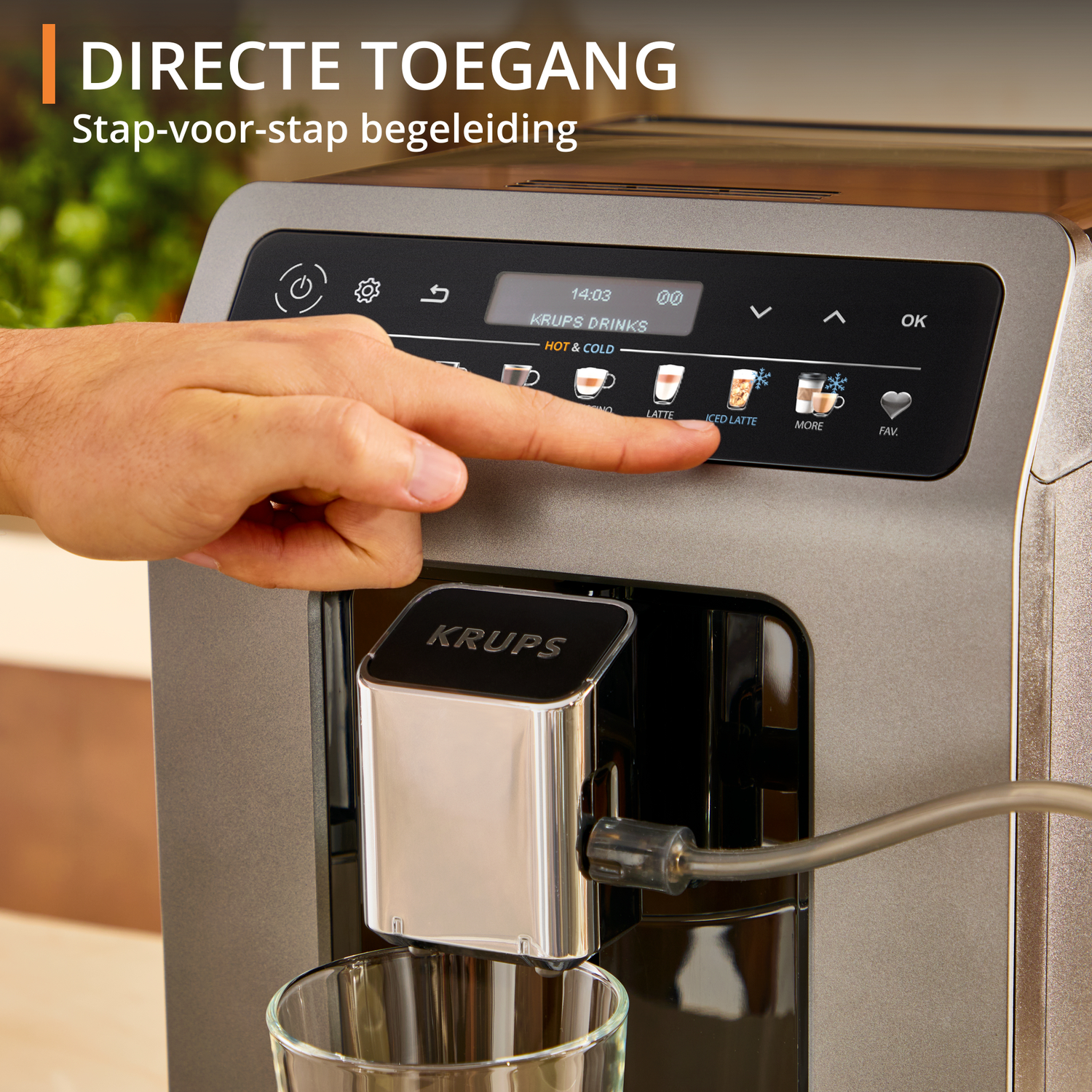 A hand presses an iced latte button on a Krups coffee machine. The machine has a digital display showing time and drink options.