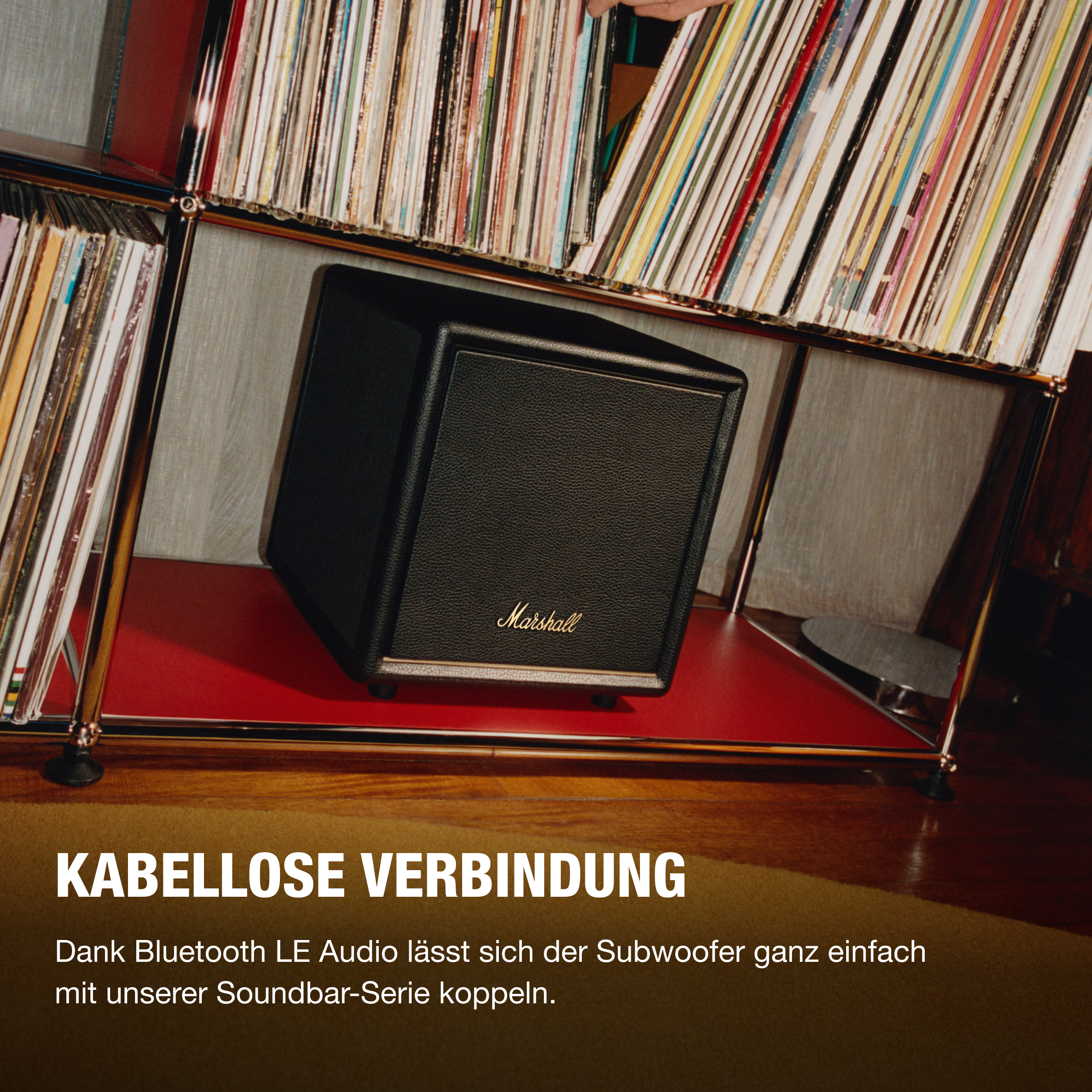 Schwarzer Marshall-Subwoofer auf rotem Regal, umgeben von Schallplatten. Text: Kabellose Verbindung.