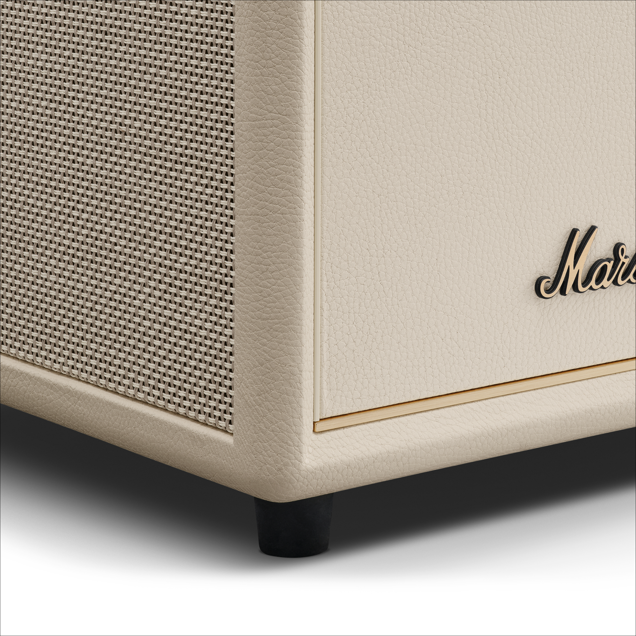 Nahaufnahme eines cremefarbenen Lautsprechergehäuses mit schwarzen Füßen. Es hat eine Gitterabdeckung und das Marshall-Logo.