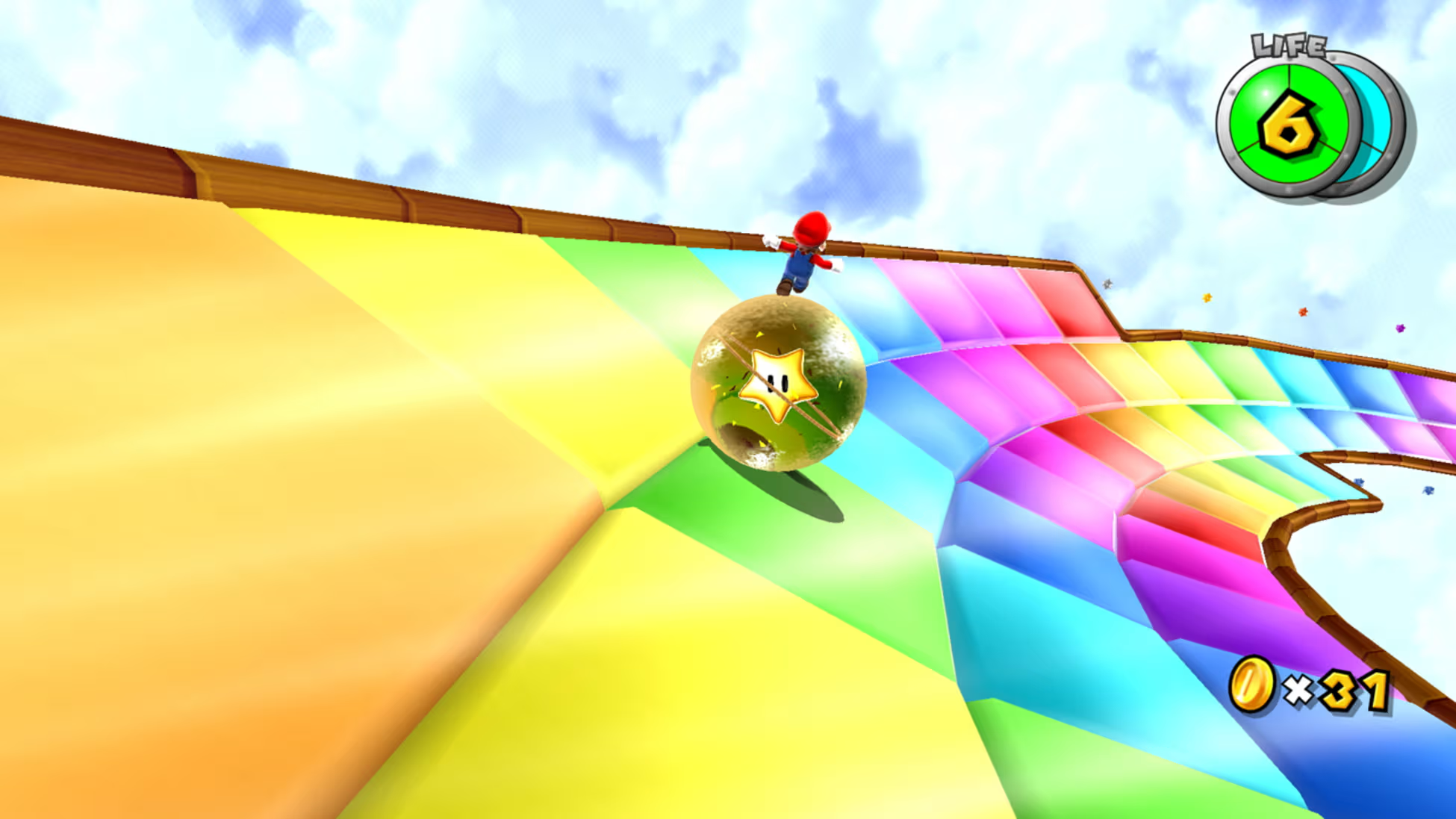 Mario su una pista arcobaleno, che cavalca una palla a stella. Il cielo è blu con nuvole. L'interfaccia di gioco mostra vite e monete.