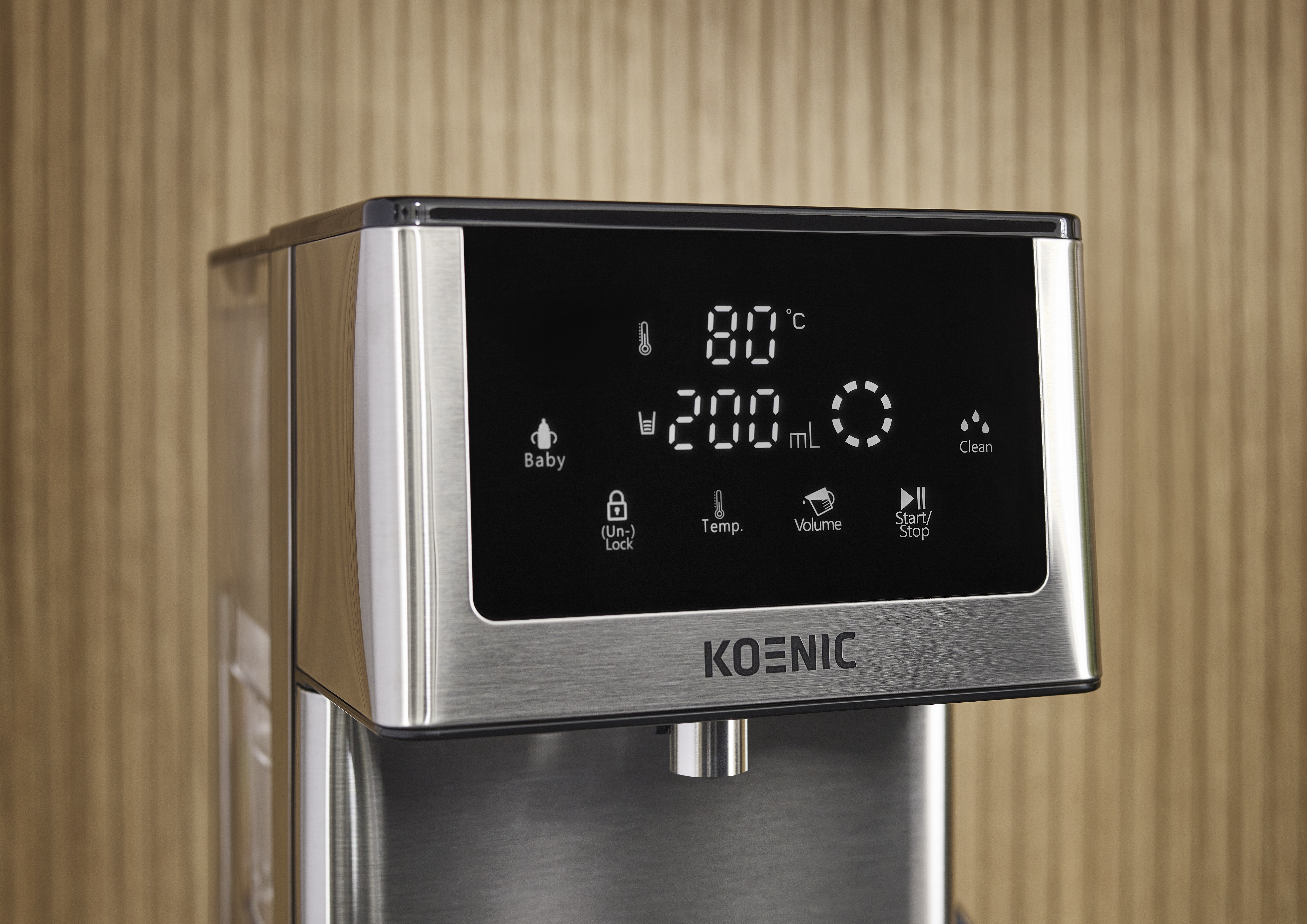 Ein Koenic-Wasserspender zeigt 80°C, 200 ml und Steuerungssymbole auf dem Display. Der Hintergrund ist eine Holzoberfläche.