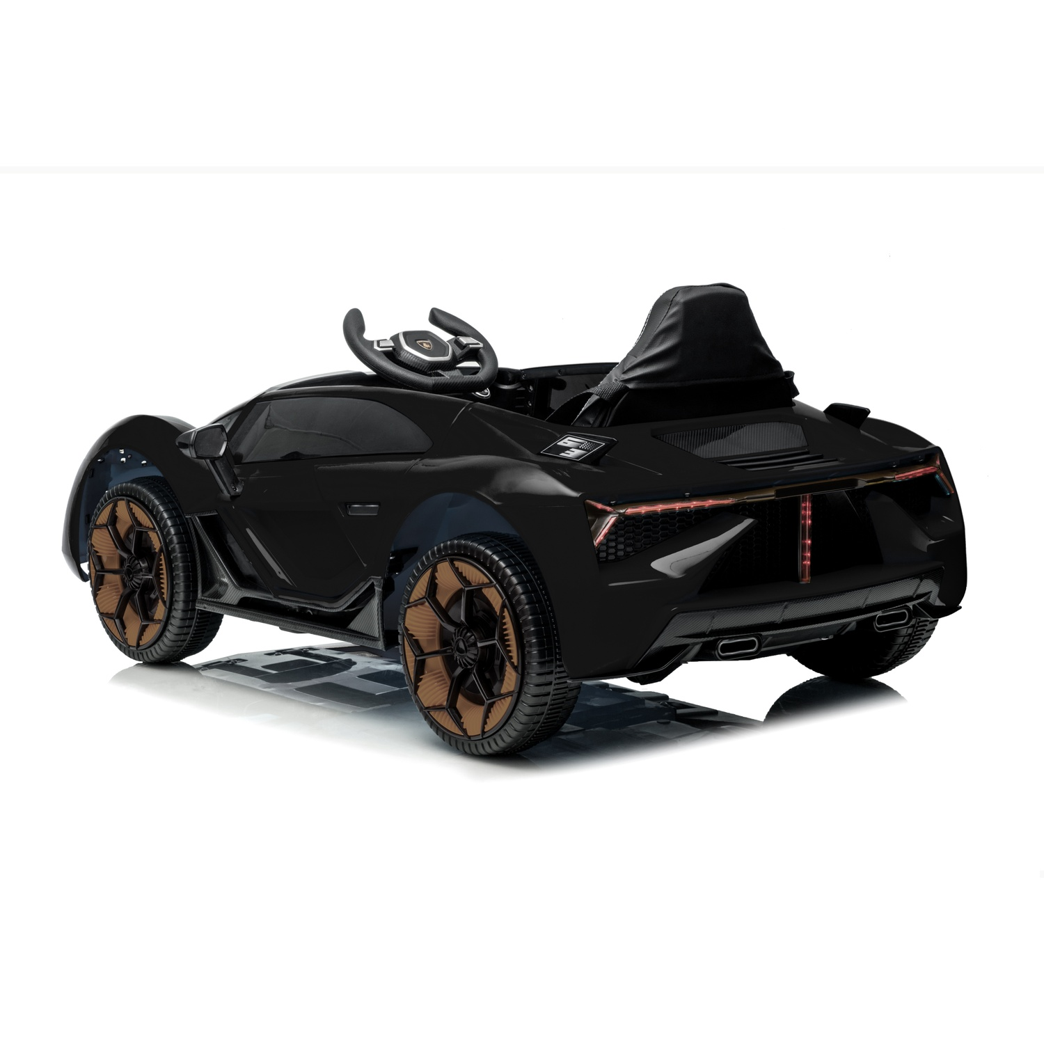 A black toy car with brown wheels sits on a white surface. It has a steering wheel and a black seat.