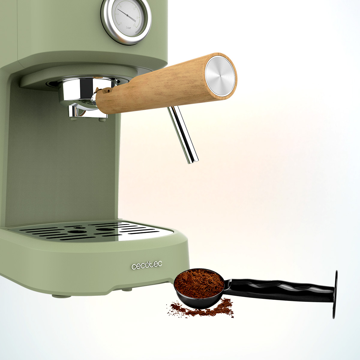 Una máquina de espresso verde oliva con mango de madera. Una cuchara de café molido está a su lado. Un medidor en la parte superior.