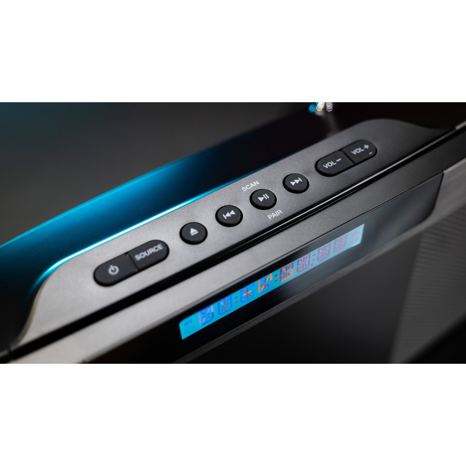 Primo piano di un dispositivo audio nero con pulsanti: Sorgente, Scansione, Associa, controllo volume e un display.