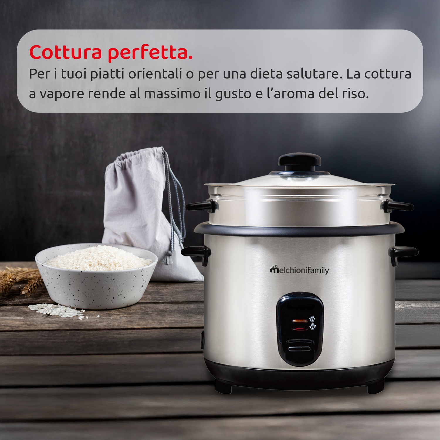 Una cuociriso su un tavolo di legno con una ciotola di riso, un sacchetto e testo in italiano. La cuociriso è argentata.