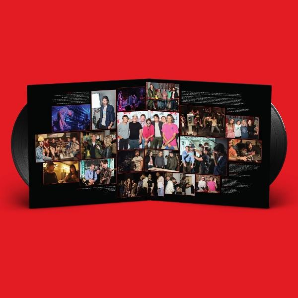Ein offenes Albumcover zeigt Fotos von Personen, wahrscheinlich einer Band, im Inneren. Auf jeder Seite befindet sich eine Schallplatte. Roter Hintergrund.