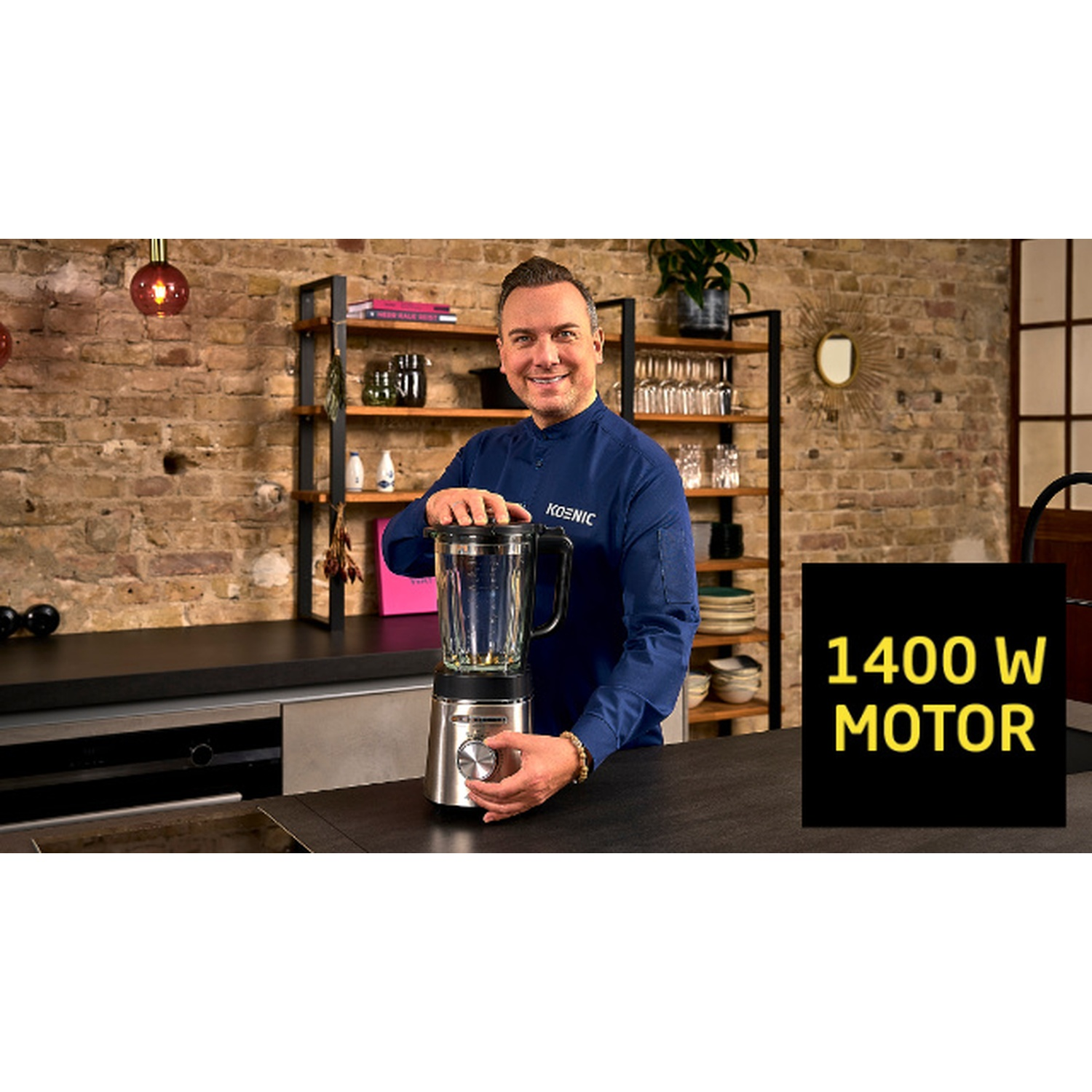 Uomo in camicia blu con frullatore. Sfondo cucina con muro di mattoni. Testo 1400 W MOTOR su quadrato nero.