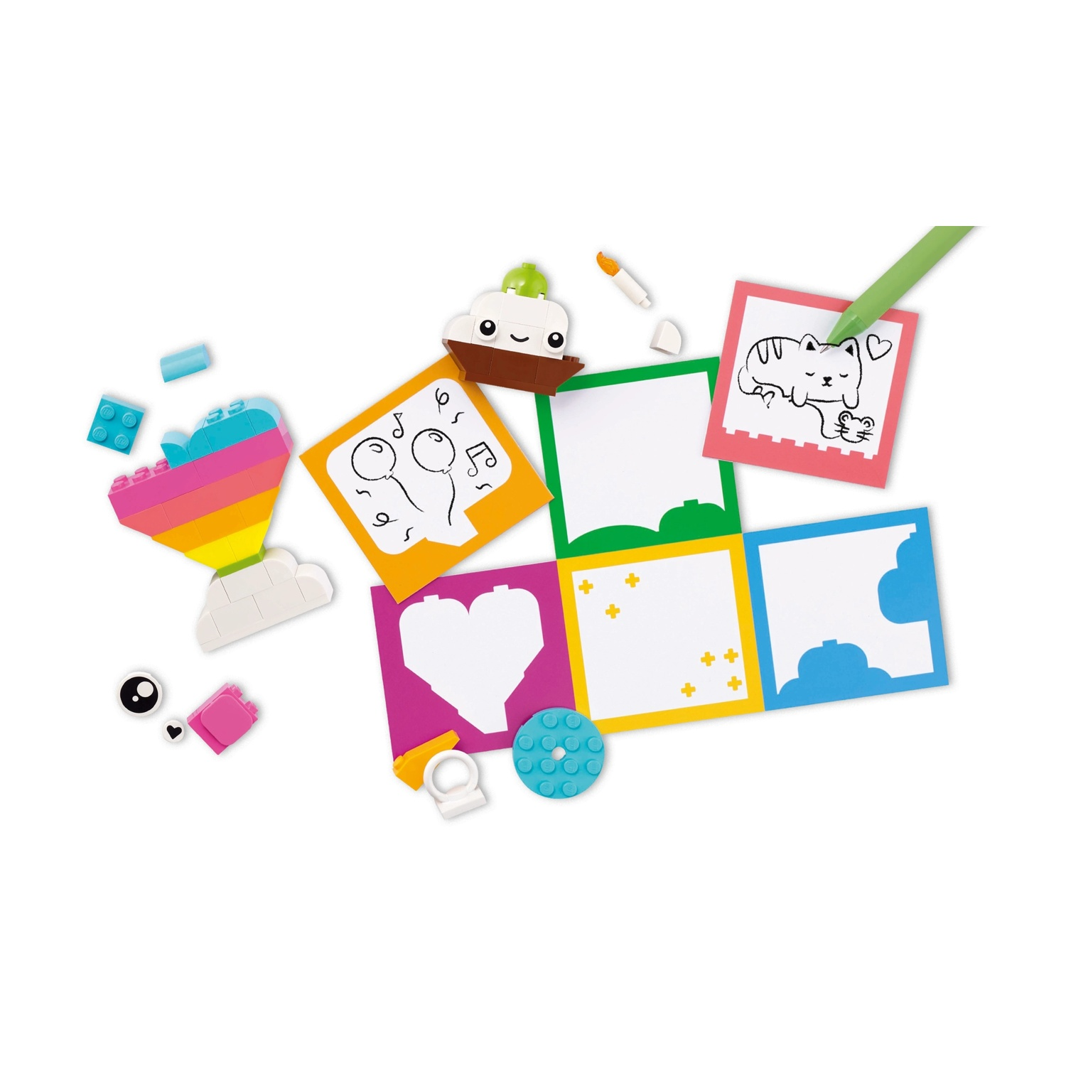 L'immagine presenta colorati mattoncini Lego e carte con disegni di un gatto, palloncini, un cuore e note musicali. Vari altri pezzi Lego sono sparsi.