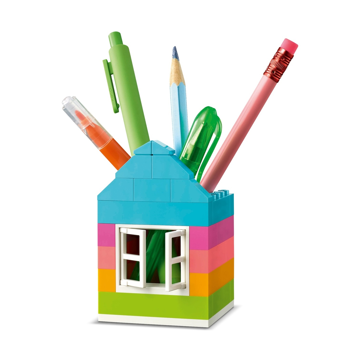 Un portapenne a forma di casa fatto di blocchi colorati. Contiene penne, matite e un evidenziatore. La finestra è aperta.