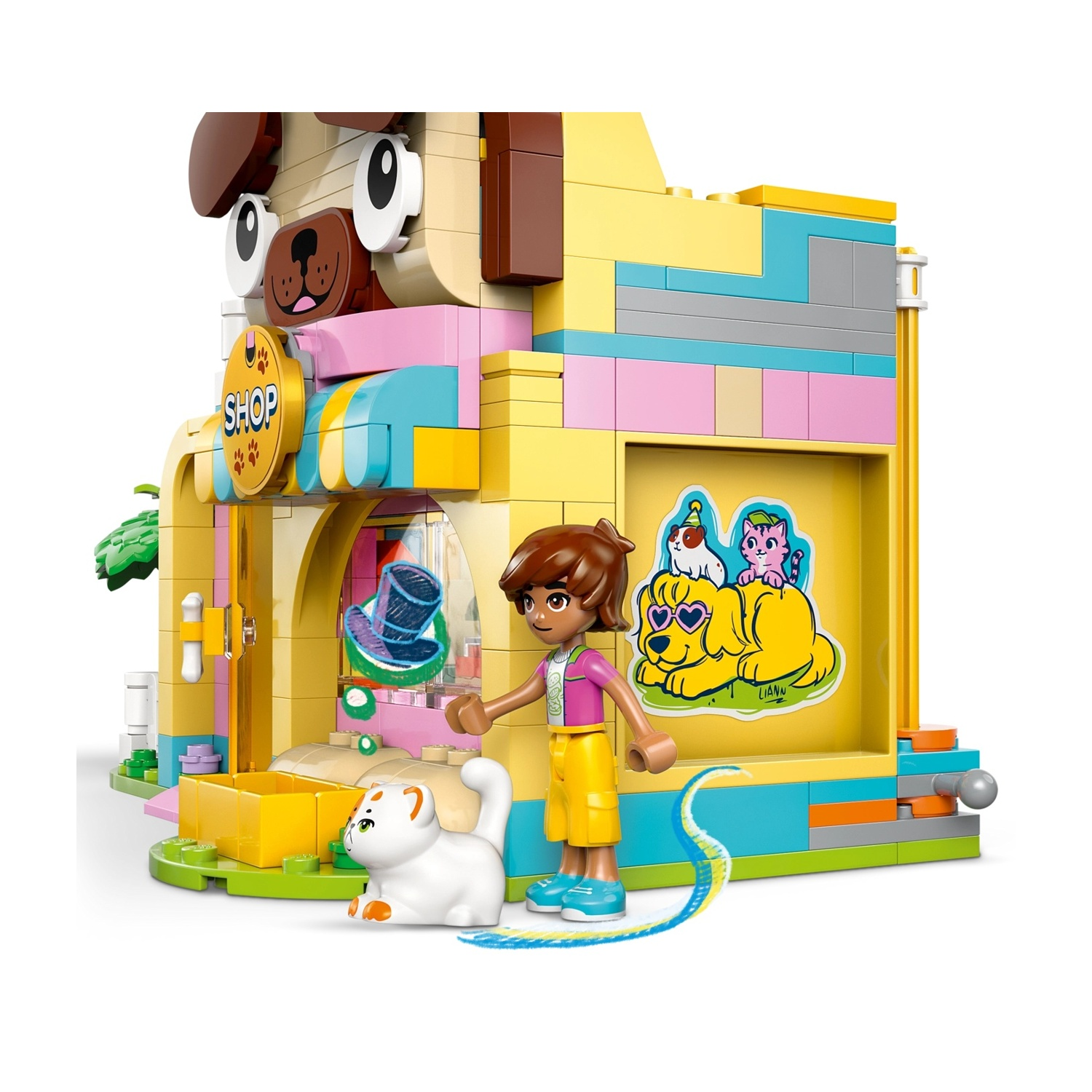 Un negozio di animali Lego con facciata a forma di cane. Una bambina accanto a un gatto bianco. Il negozio presenta adesivi di animali.