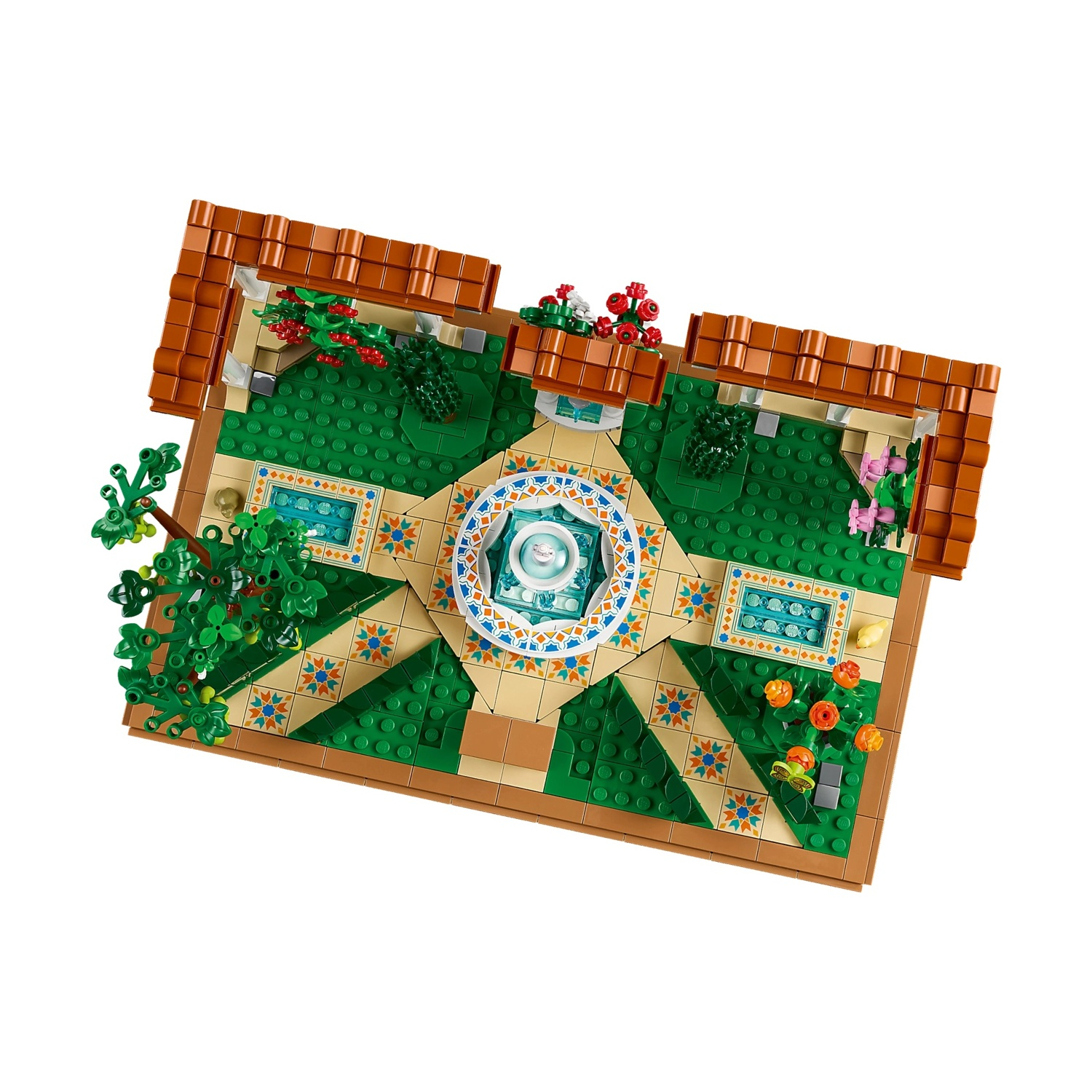 Una scena di giardino Lego con fontana, erba verde e aiuole. Muri marroni con tetti circondano il giardino, con alberi e fiori presenti.
