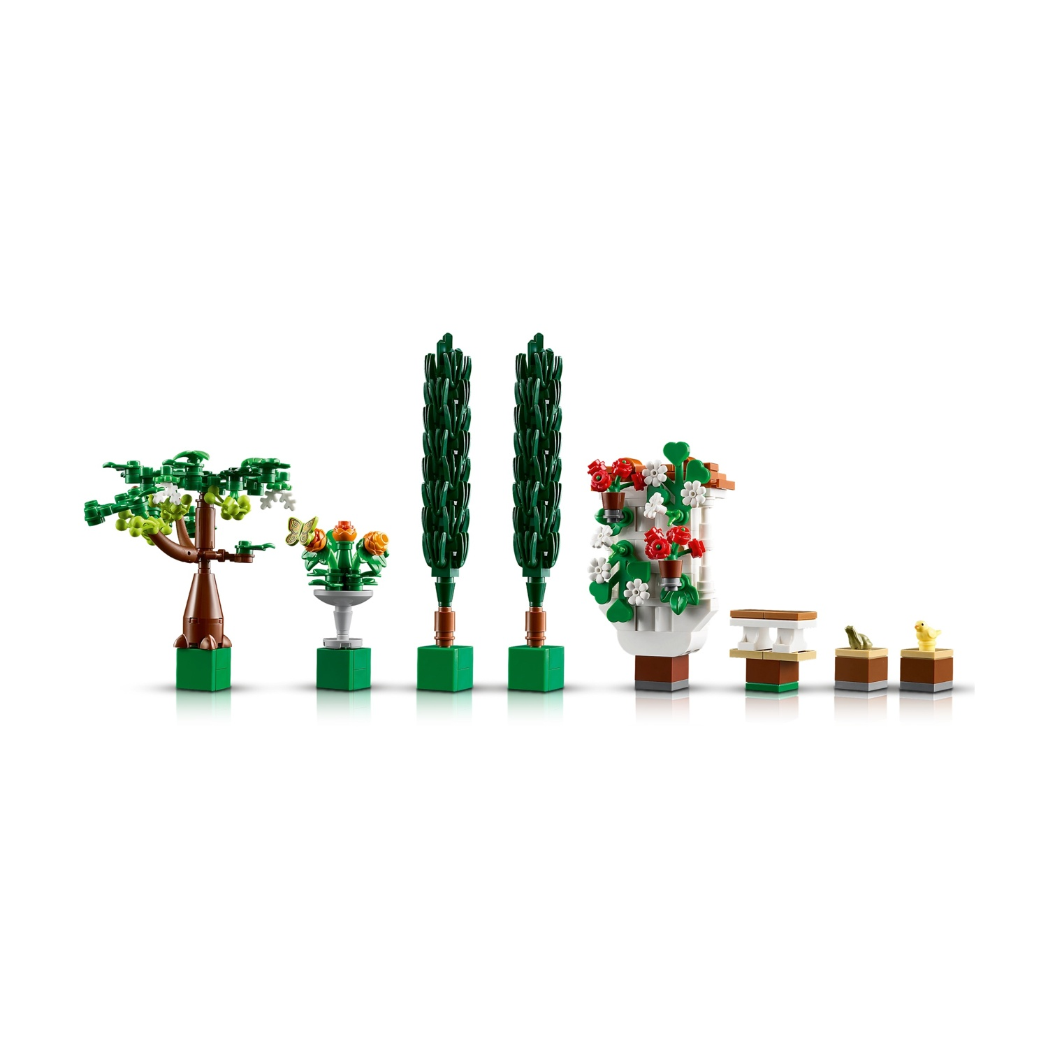 Set Lego che raffigura un giardino con alberi, fiori, una farfalla e piccoli elementi decorativi su sfondo bianco.