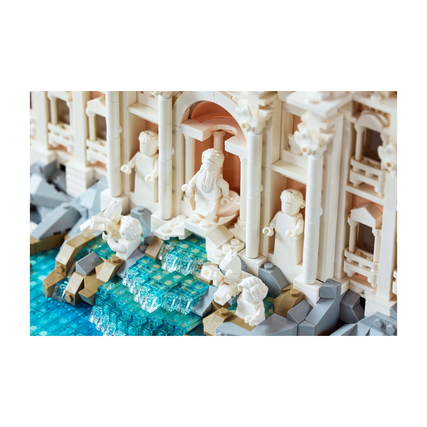 Un modello Lego di un edificio con statue e colonne bianche. L'acqua blu scorre di fronte. Edificio rosa chiaro e beige.