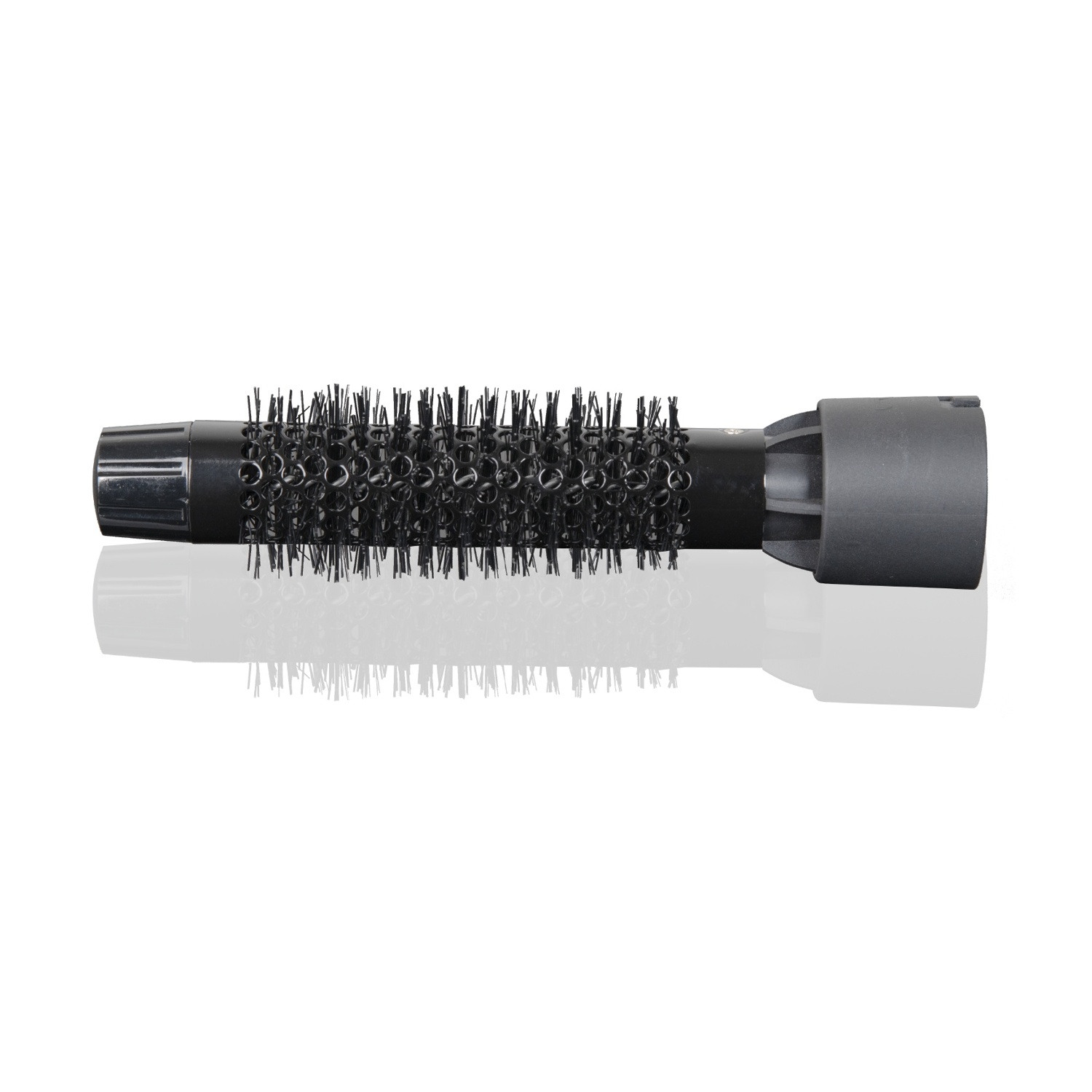 Una spazzola nera per capelli, cilindrica con setole. Riflessa su una superficie bianca, su sfondo bianco.