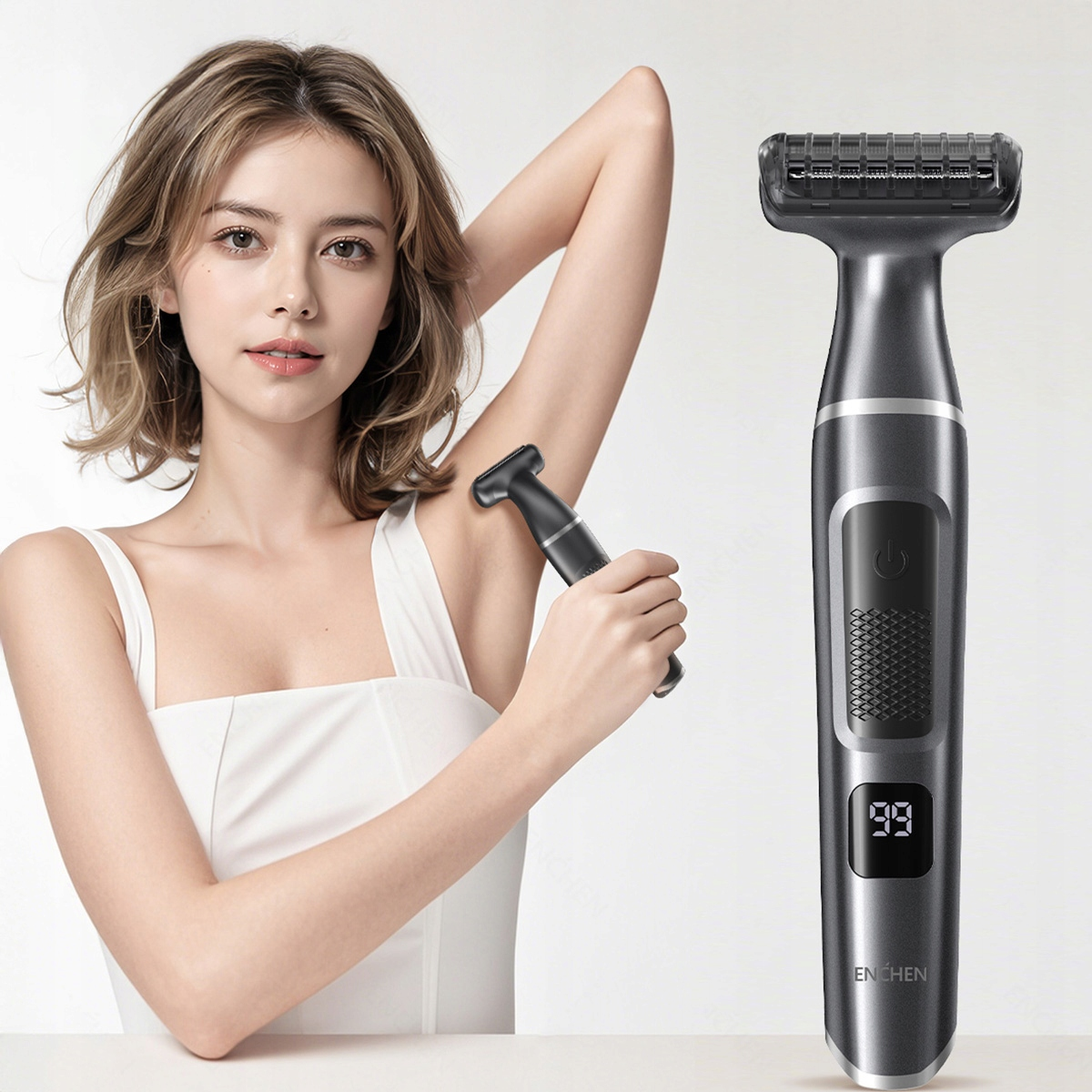 Kobieta goli pachy małą golarką elektryczną. Po prawej stronie znajduje się większa golarka elektryczna. Białe tło.