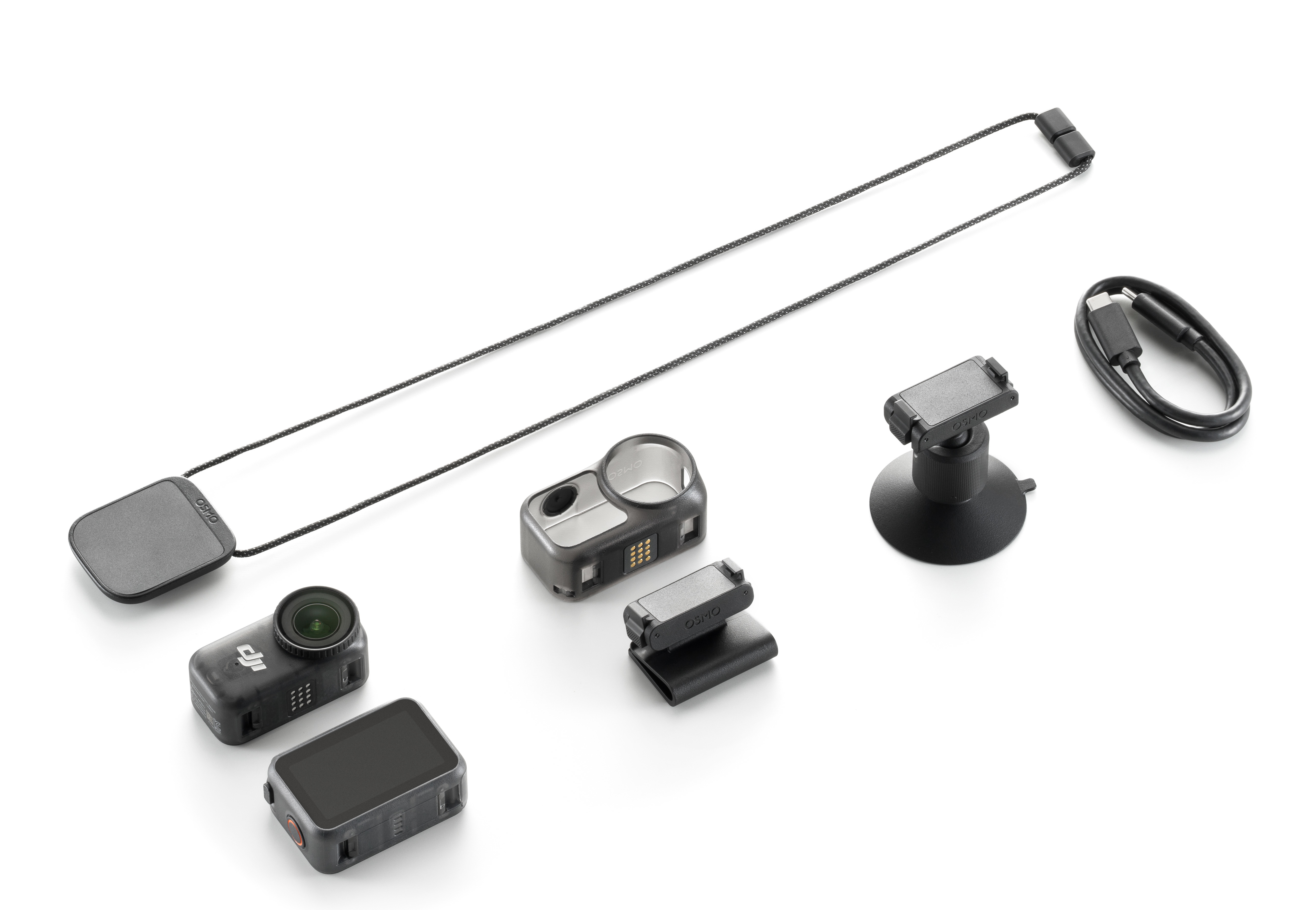 Wiele czarnych akcesoriów do aparatu na białym tle: aparat, uchwyt, kabel, smycz.