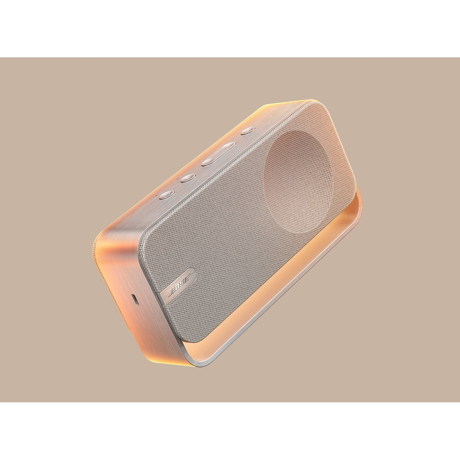 Un altoparlante Bose argentato e color legno fluttua su uno sfondo beige. Ha pulsanti in alto e una griglia.
