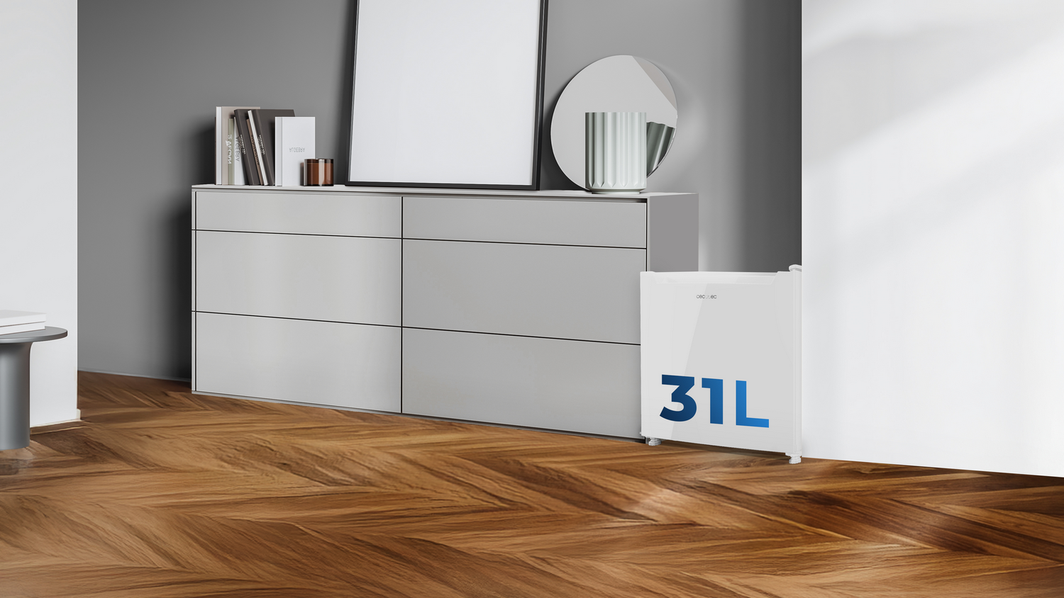 Interior con nevera, cómoda, espejo, libros y suelo de madera. La nevera tiene "31L".