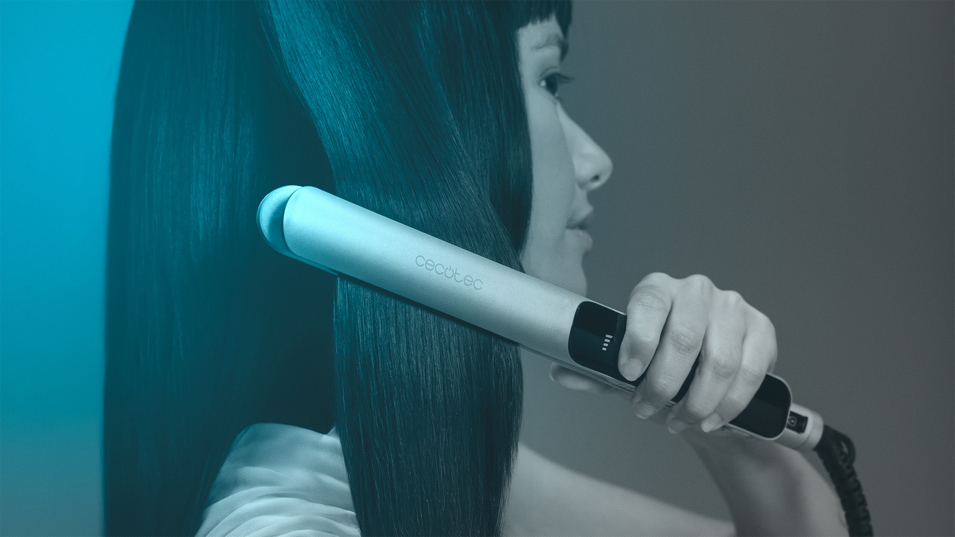 Una mujer se alisa el pelo oscuro con una plancha Cecotec. El fondo es un degradado de verde azulado y gris.