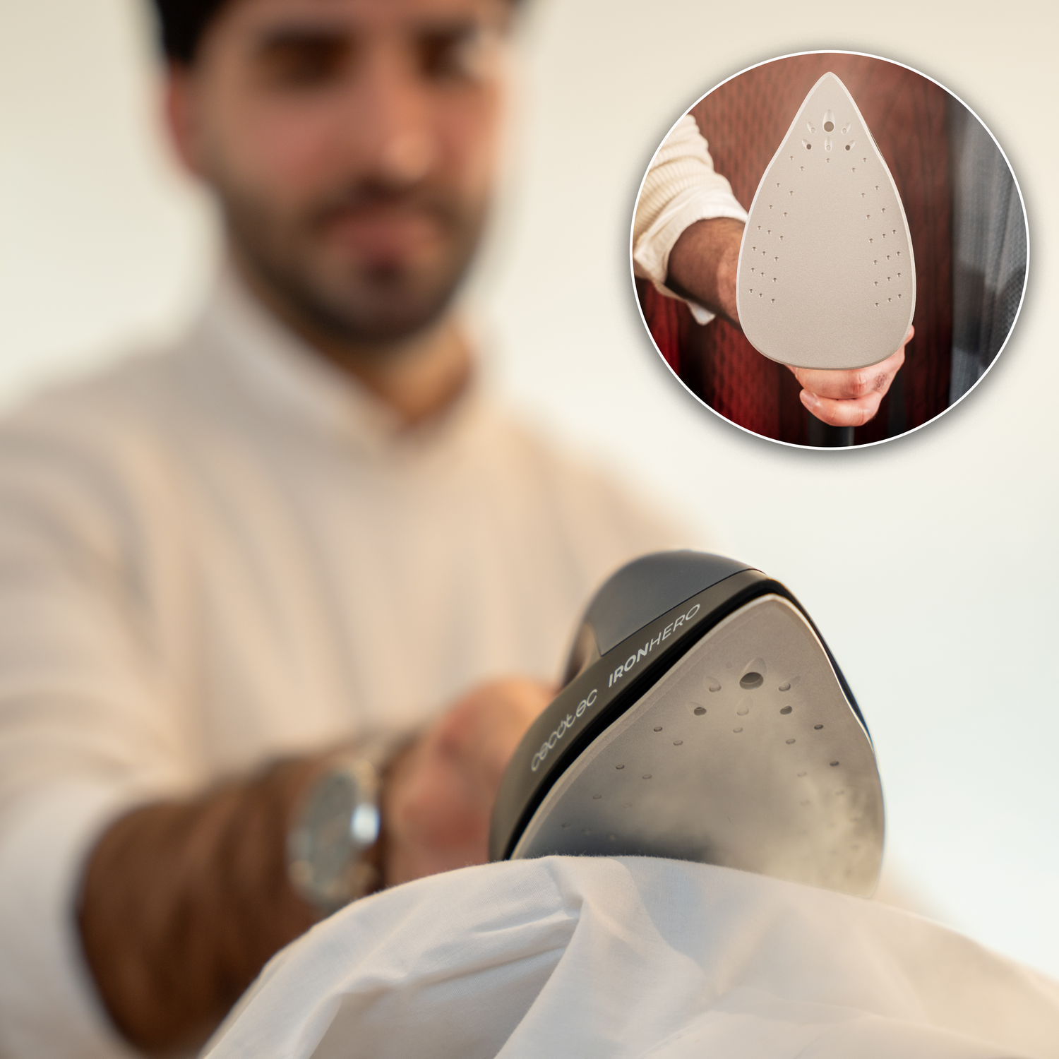 Una persona plancha una camisa blanca con una plancha negra. Una incrustación circular muestra la suela de la plancha.