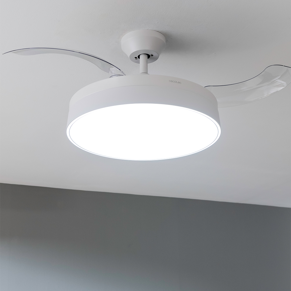 Un ventilador de techo blanco con luz integrada. Las aspas del ventilador son transparentes. El fondo muestra un techo blanco y una pared gris.