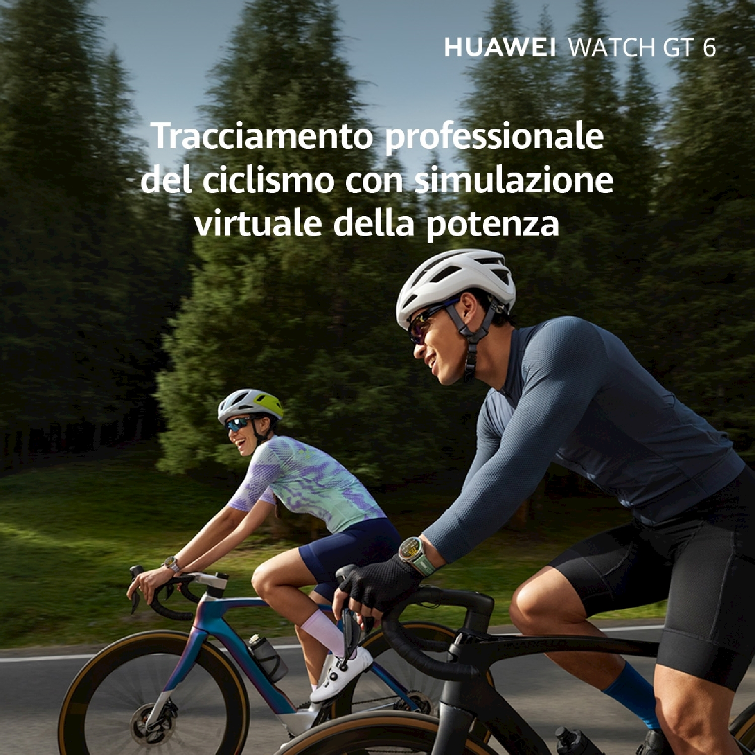 Due ciclisti in bicicletta, con caschi e abbigliamento sportivo. Alberi sullo sfondo. Un orologio al polso di uno dei ciclisti.