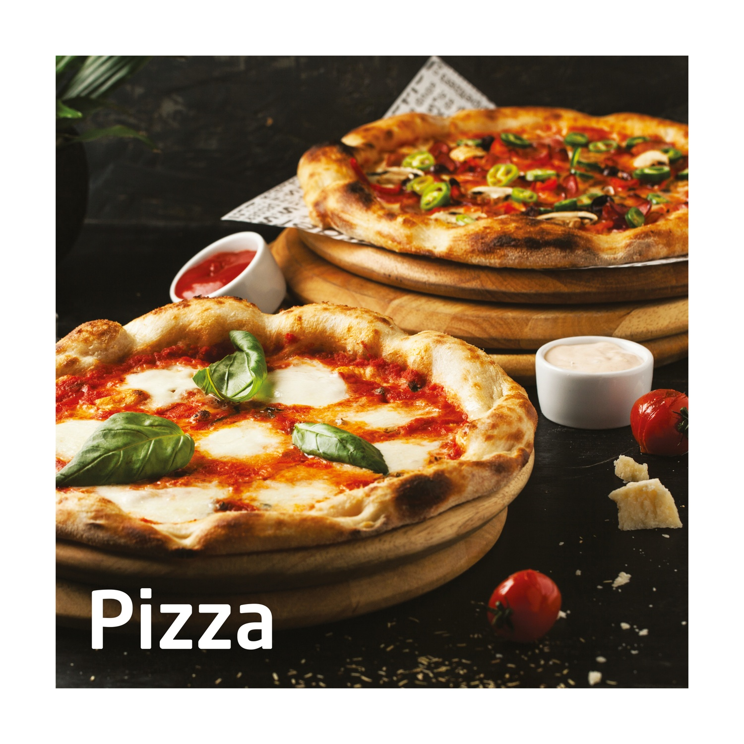 Due pizze su tavole di legno. Una con basilico e mozzarella, l'altra con verdure. Contorni: salse, pomodori e formaggio.