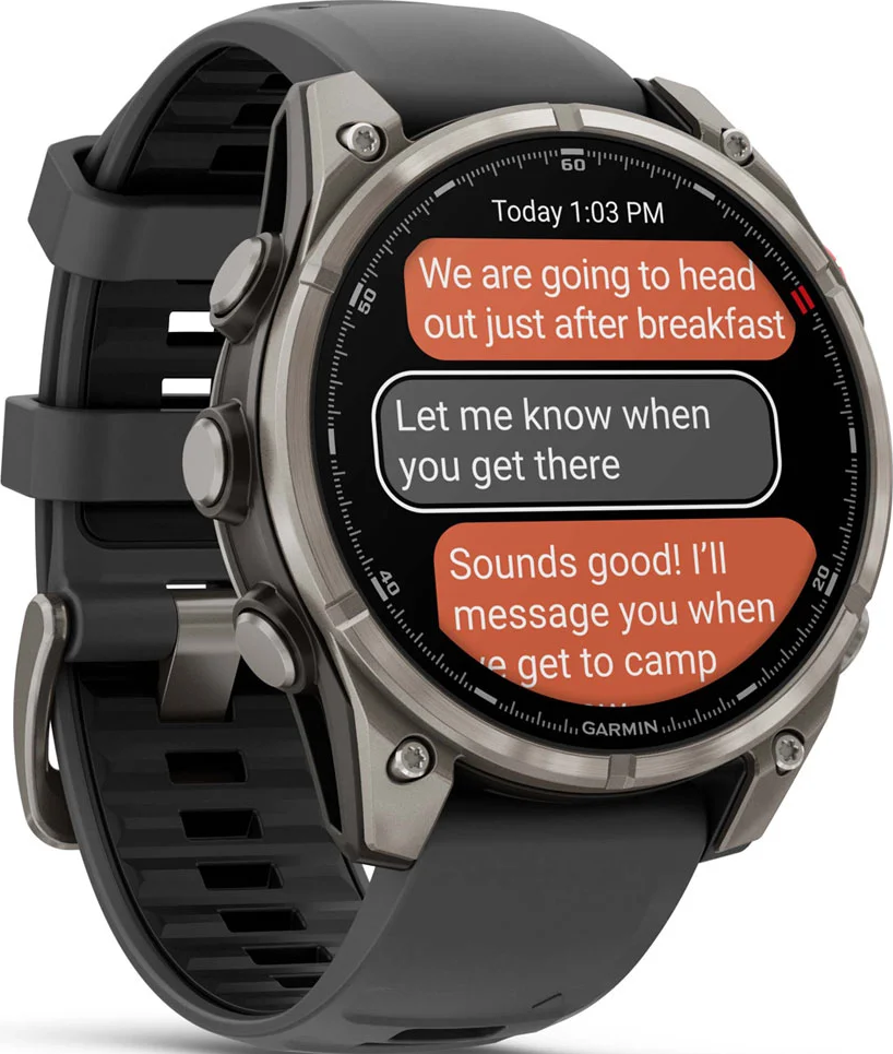 Une montre intelligente affichant des SMS. L'écran montre une conversation sur des projets. La montre est noire et argentée avec un bracelet noir.