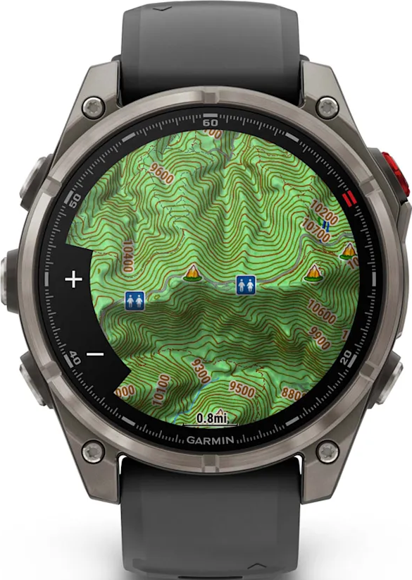 Smartwatch affichant une carte topographique. La montre est grise avec un bracelet noir. La carte montre les courbes de niveau, marqueurs et texte.