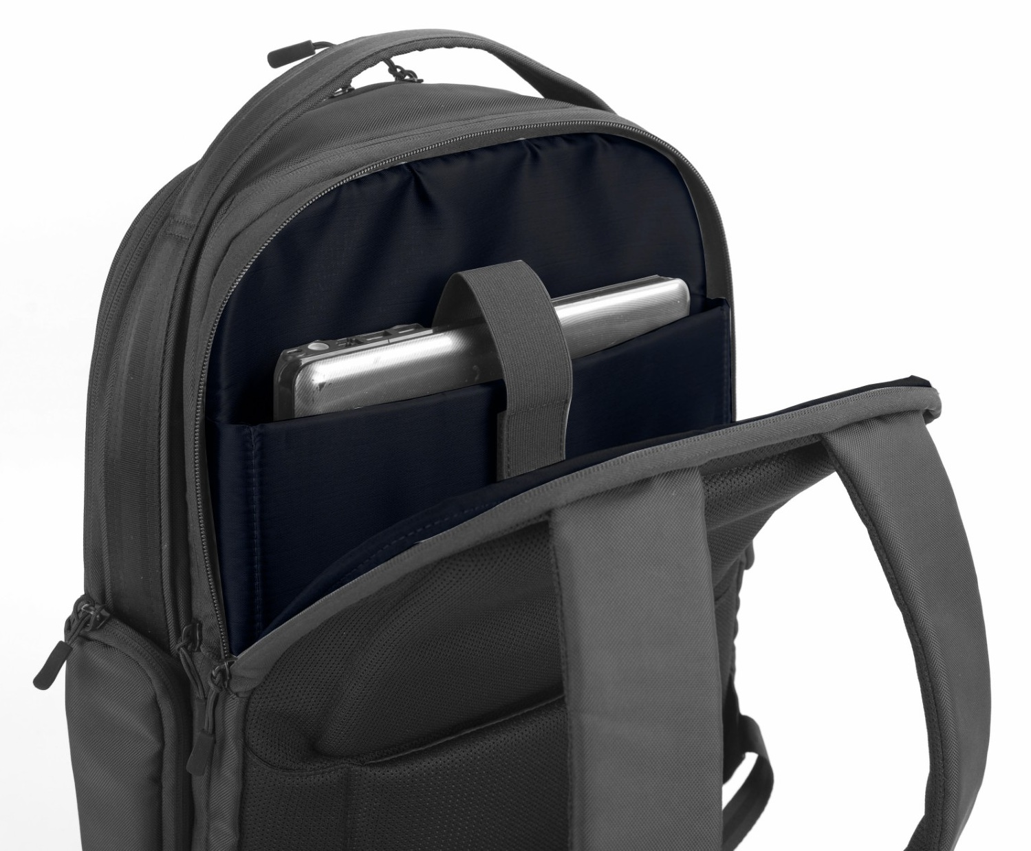 Otwarty szary plecak z niebieskim wnętrzem. Srebrny tablet jest w kieszeni. Widoczne zamki i paski. Białe tło.