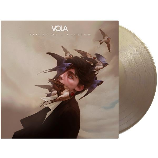 Albumcover mit einem Gesicht, umgeben von Vögeln, neben einer goldenen Schallplatte.