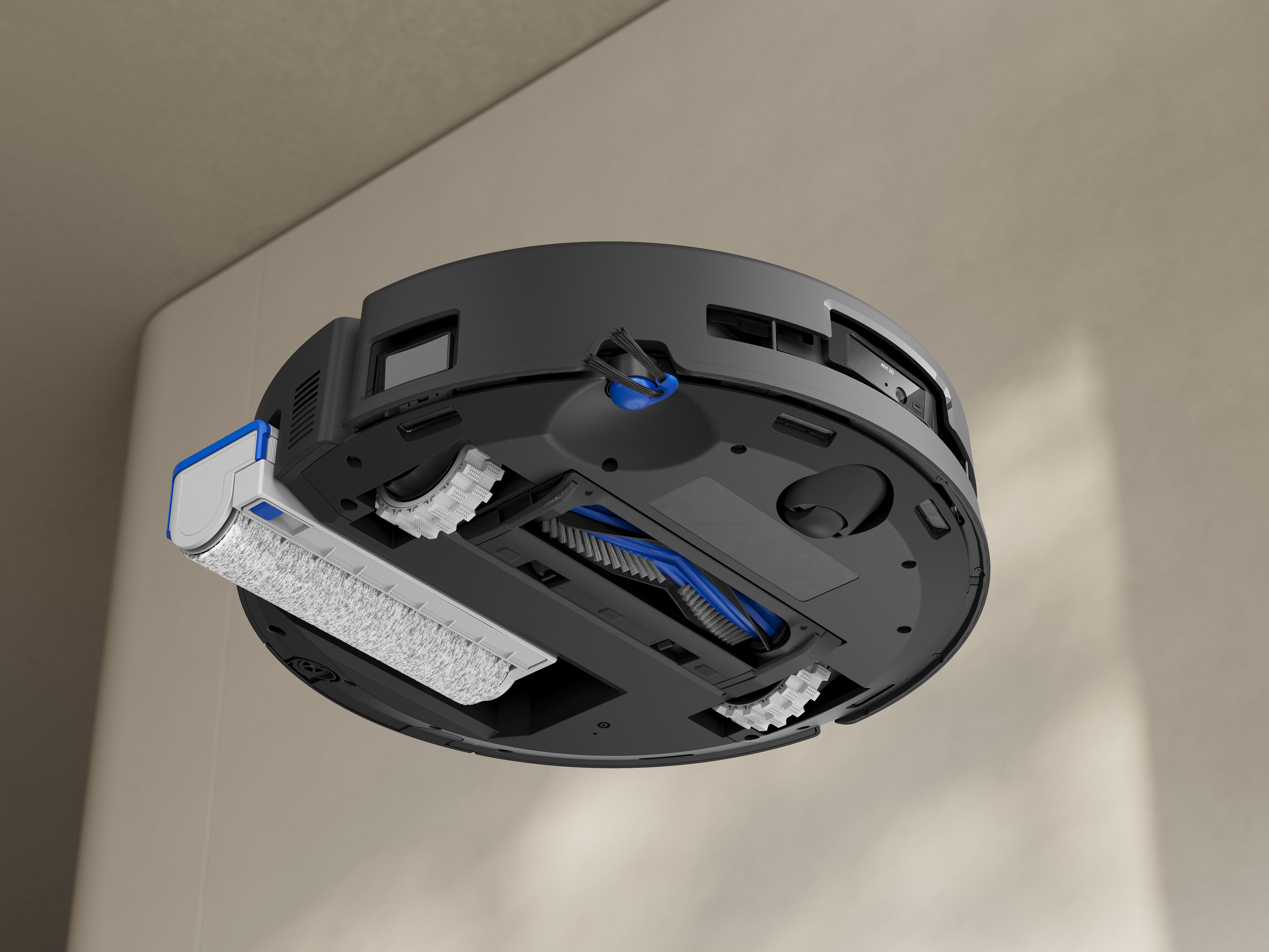 Spód robota odkurzacza. Widoczne są czarne i niebieskie części. Są szczotki i podkładka do czyszczenia.