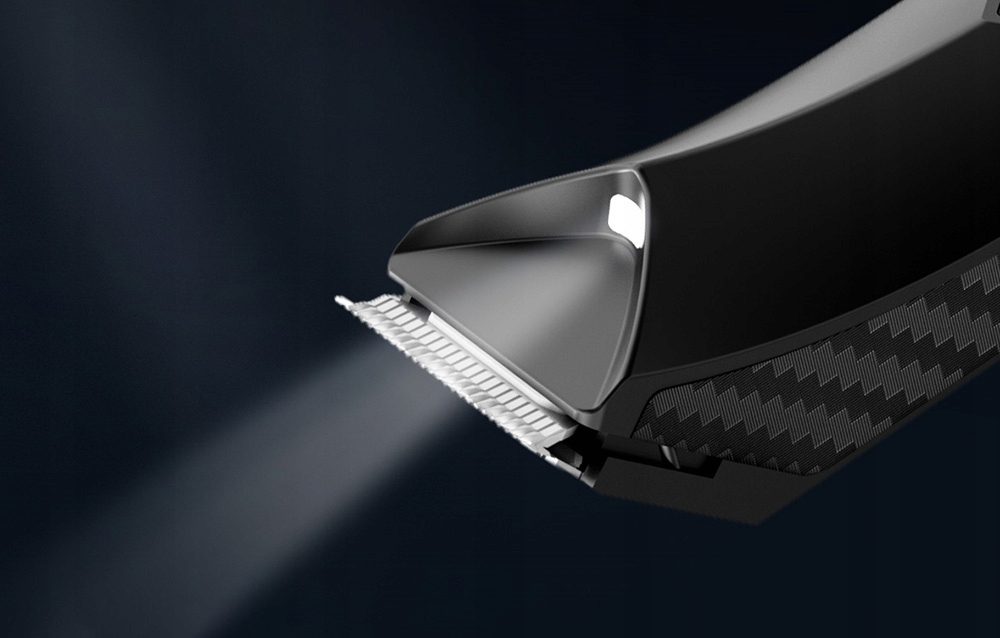 Zbliżenie czarnej golarki elektrycznej z wiązką światła. Ostrze jest metalowe, tło ciemnoniebieskie.