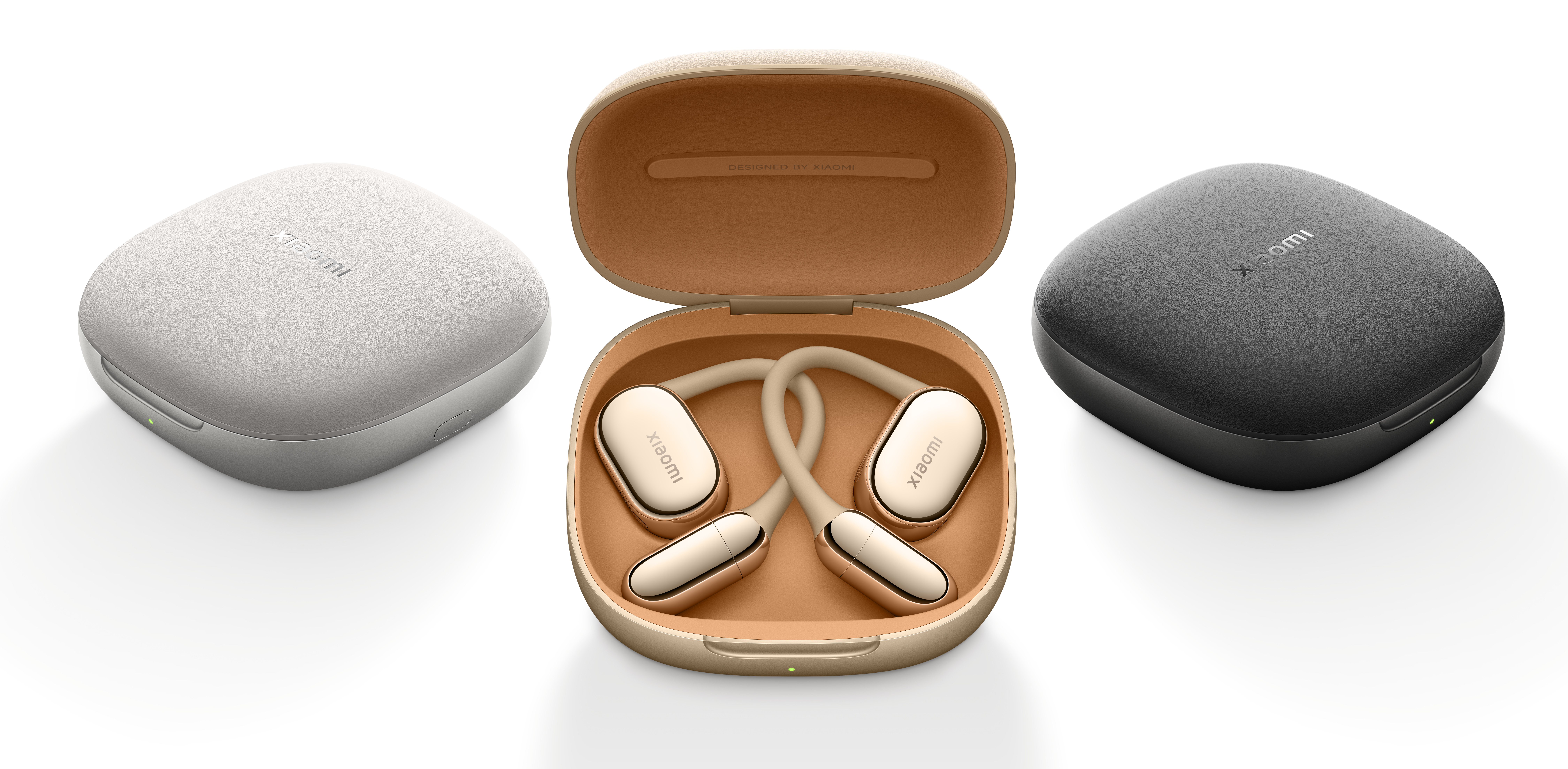 Trzy etui na słuchawki Xiaomi: białe, złote i czarne. Złote etui otwarte ze słuchawkami w środku. Wszystkie etui mają logo Xiaomi.