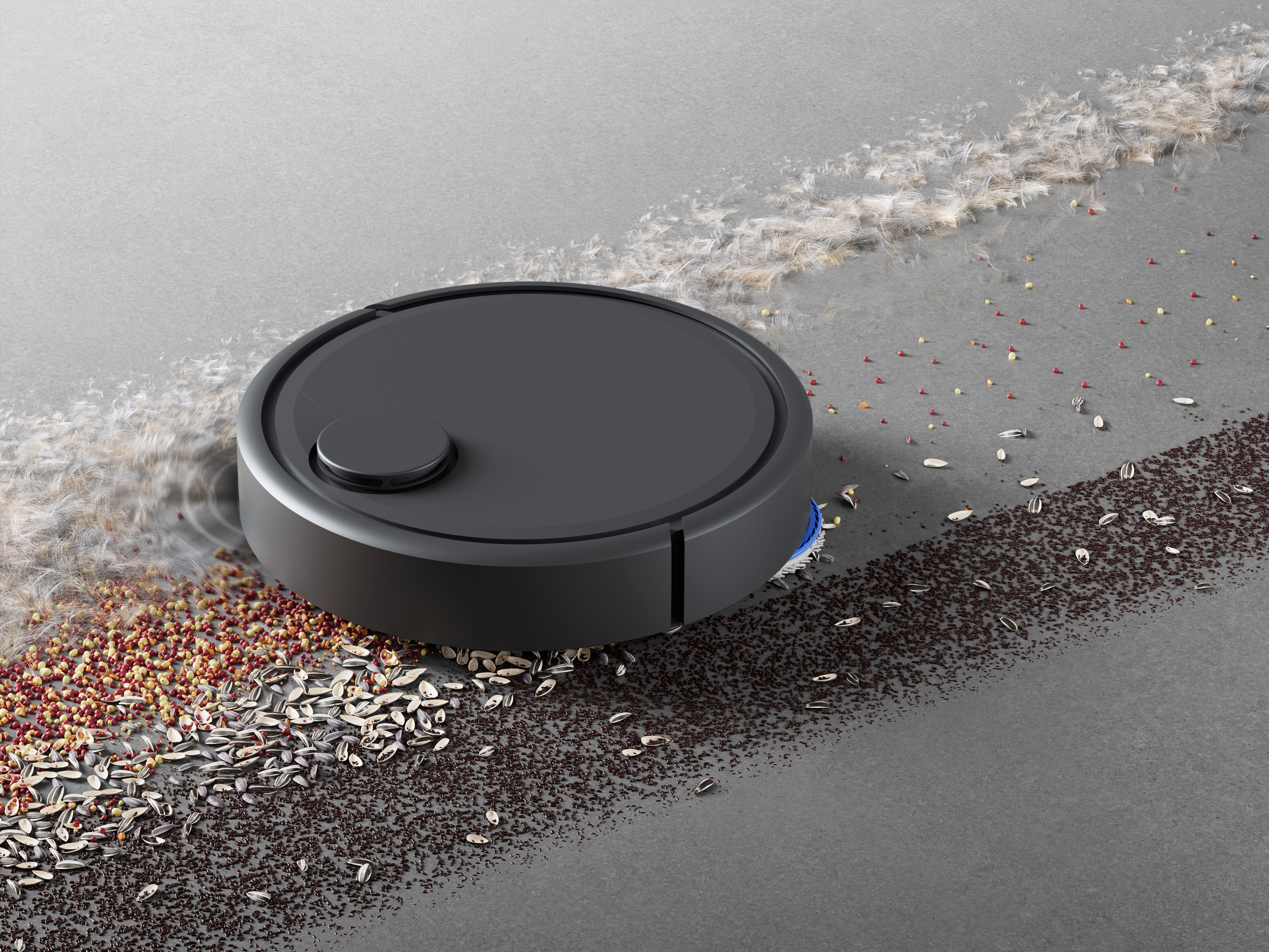 Czarny robot sprzątający czyści nasiona i zanieczyszczenia na szarej podłodze. Odkurzacz ma szczotkę i mały przycisk.