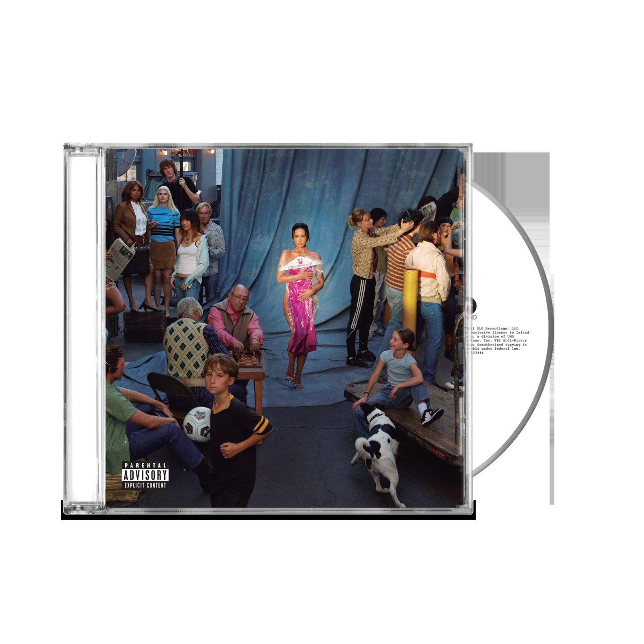 CD-Cover mit vielen Leuten, eine Frau in einem rosa Kleid, ein Junge mit einem Fußball und ein Hund.