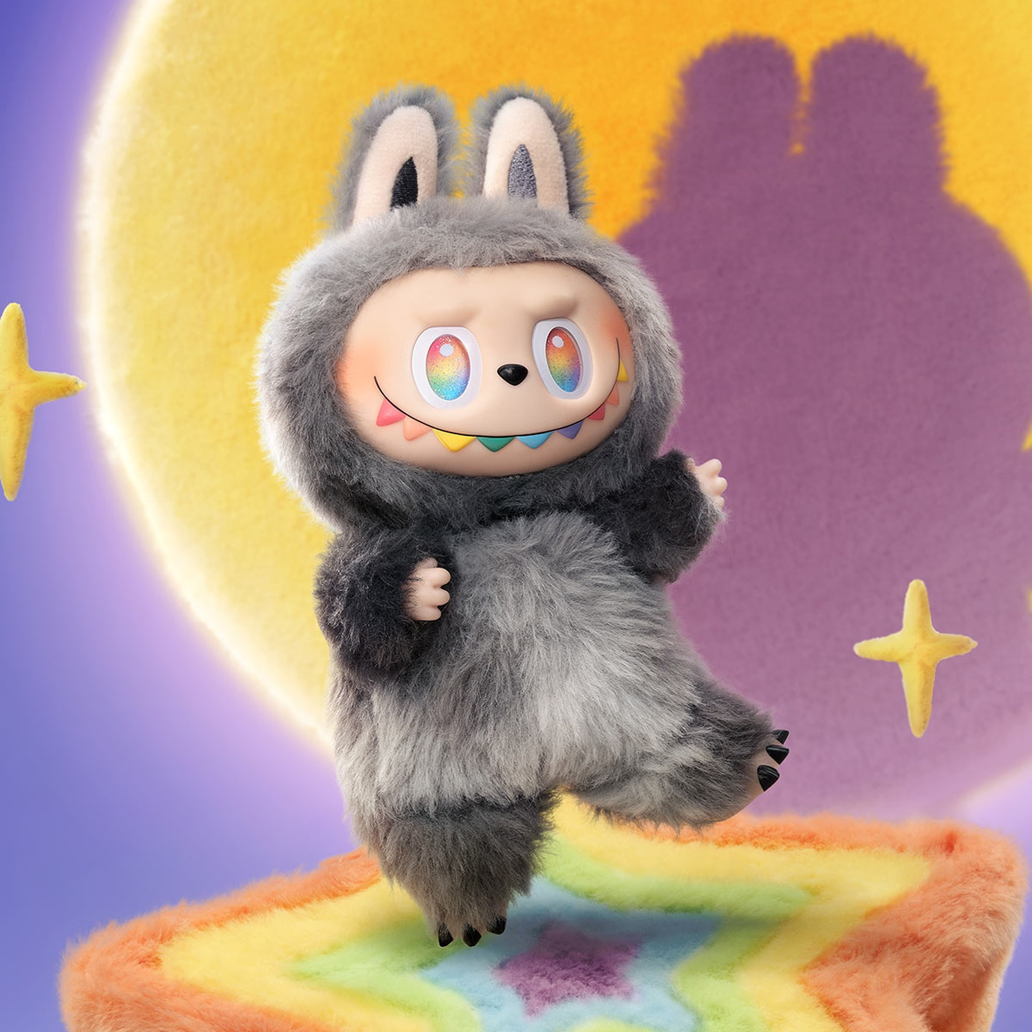 Un personaggio di peluche simile a un coniglio con occhi e denti arcobaleno è in piedi su un tappeto arcobaleno contro uno sfondo di luna e stelle.