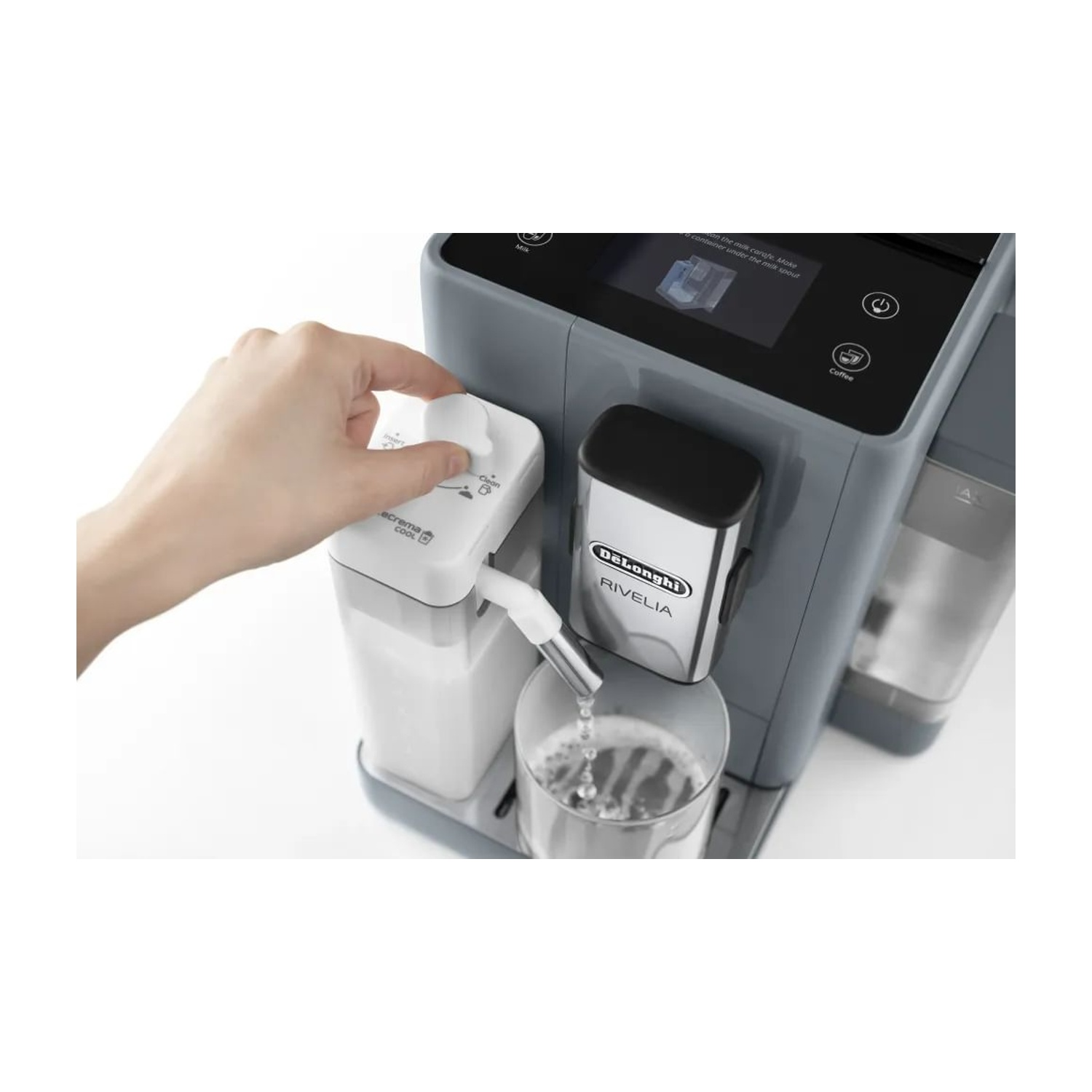 Una mano regola un quadrante su una macchina da caffè De'Longhi. L'acqua scorre in un bicchiere. La macchina è grigia e ha uno schermo.