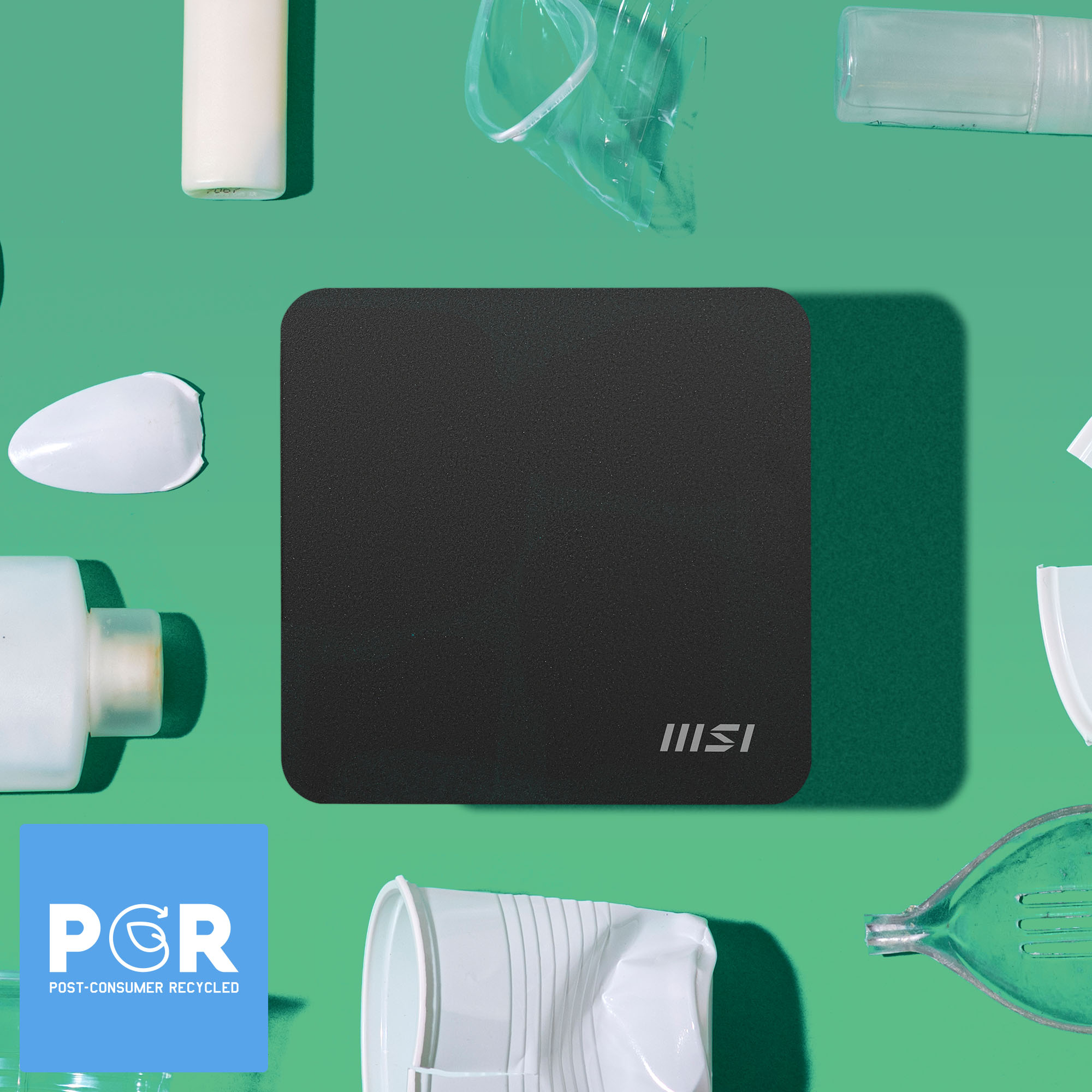 Ein schwarzes Quadrat mit MSI-Logo, umgeben von recycelten Gegenständen: Plastikflaschen, Behältern und einem PCR-Logo auf grünem Hintergrund.