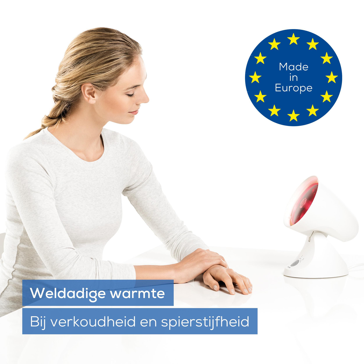 A woman looks at a white lamp with a red light. The image shows a EU sign that says 'Made in Europe'. Text: 'Soothing warmth'.