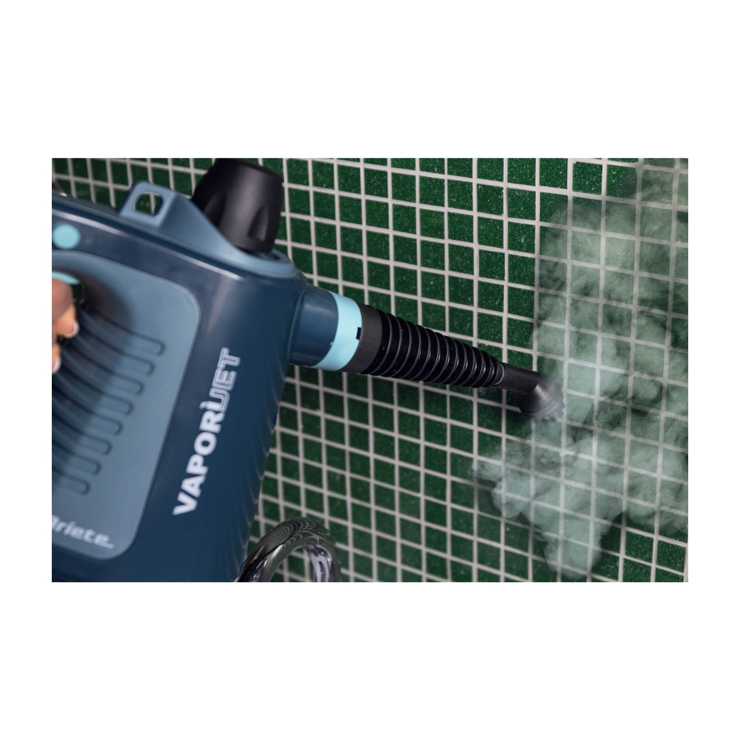 Un pulitore a vapore blu viene utilizzato contro un muro di piastrelle verdi. Viene emesso vapore. Il marchio è VAPORJET.