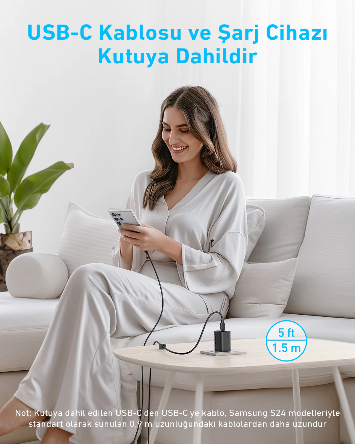 Bir kadın, masadaki bir şarj bloğuna bağlı bir telefon kullanırken gülümsüyor. Metinde 'USB-C kablosu ve şarj cihazı dahildir' yazıyor.