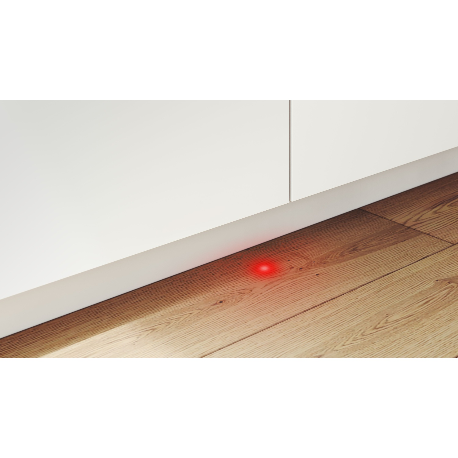 Un muro bianco incontra un pavimento in legno. Una luce rossa è sul pavimento.