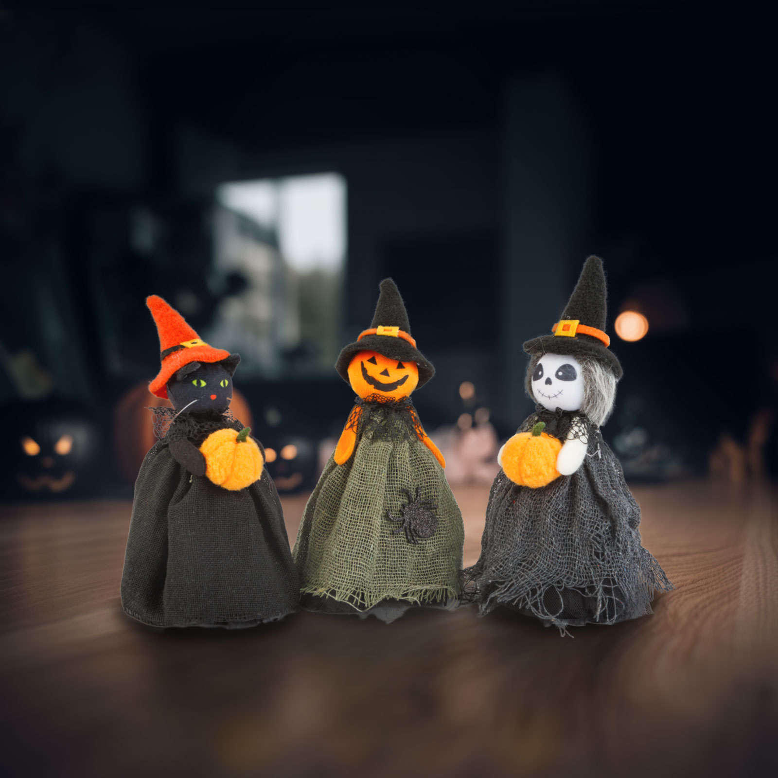 Három Halloween-figura: egy fekete macska, egy töklámpás és egy csontváz, mindegyik tököt tart, boszorkánykalapot visel. Sötét háttér.