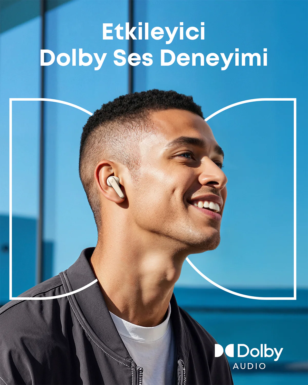 'Dolby Ses Deneyimi'ni tanıtan, kulaklık takmış gülen bir adam. Mavi arka plan ve Dolby Audio logosu görünüyor.