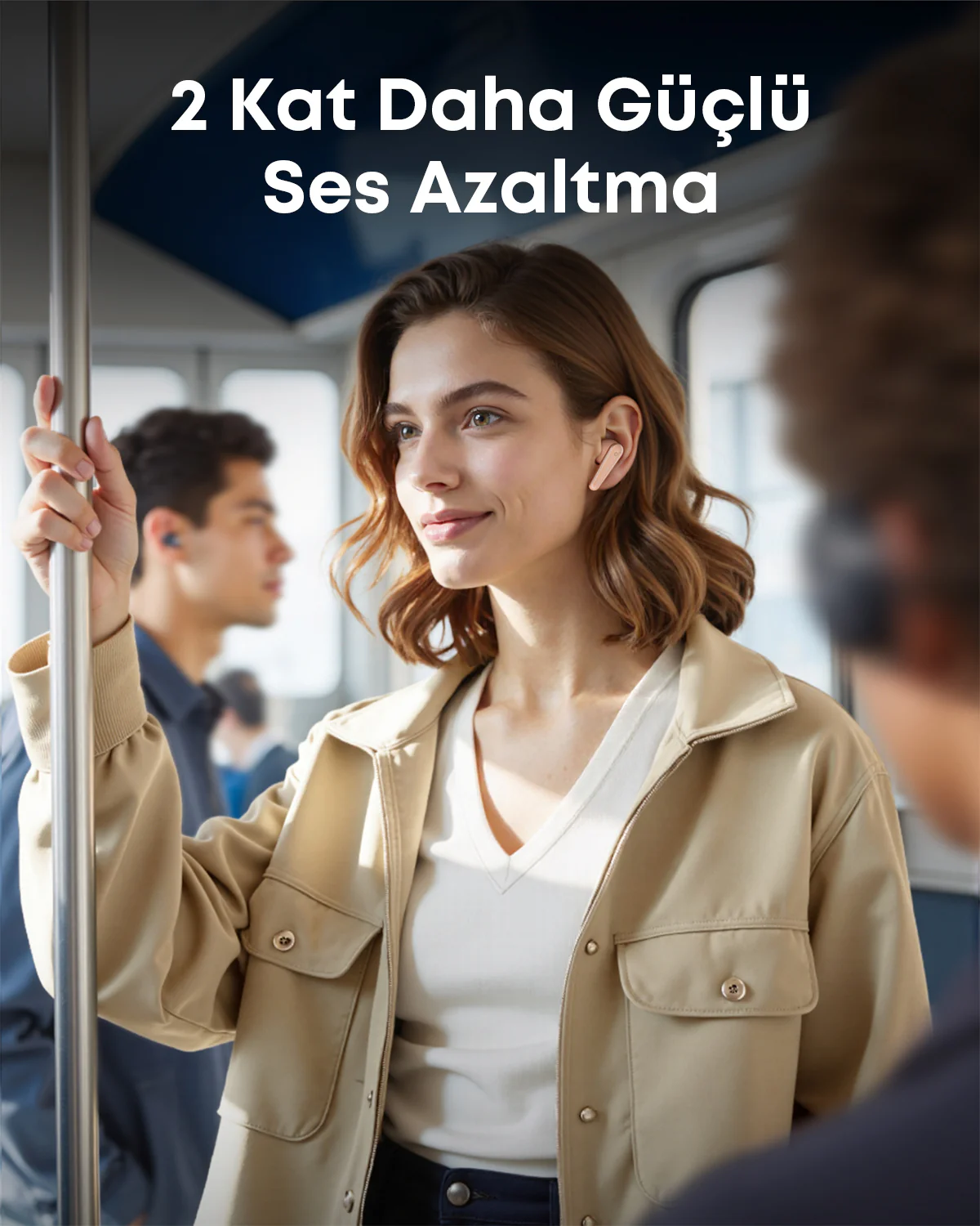 Kulaklık takan bir kadın, trende bir direğe tutunurken gülümsüyor. Arka planda diğer yolcular görülüyor.