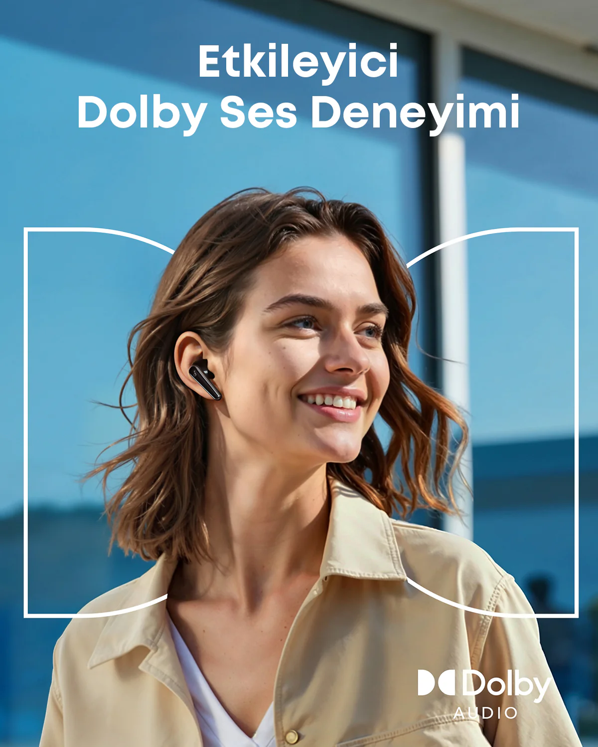 Kulaklık takan gülen bir kadın. Bej bir ceket giyiyor. Arka plan mavi bir gökyüzü ve 'Dolby Audio' yazısı.