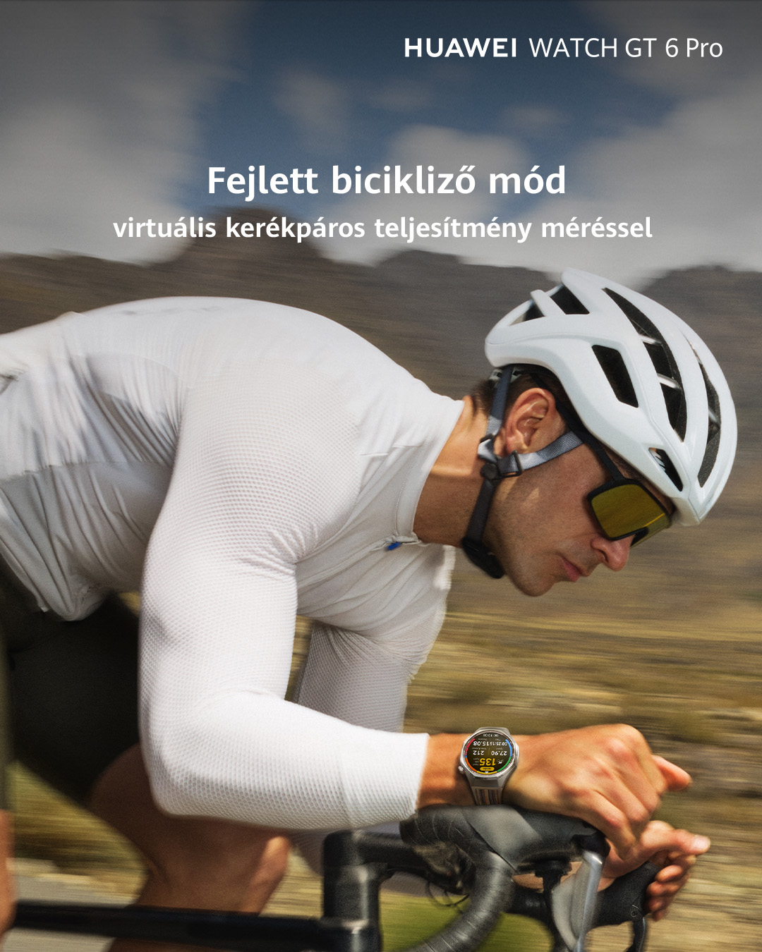 Egy kerékpáros fehér sisakban és ingben kerékpározik. Egy okosóra teljesítményadatokat mutat. A háttér elmosódott.