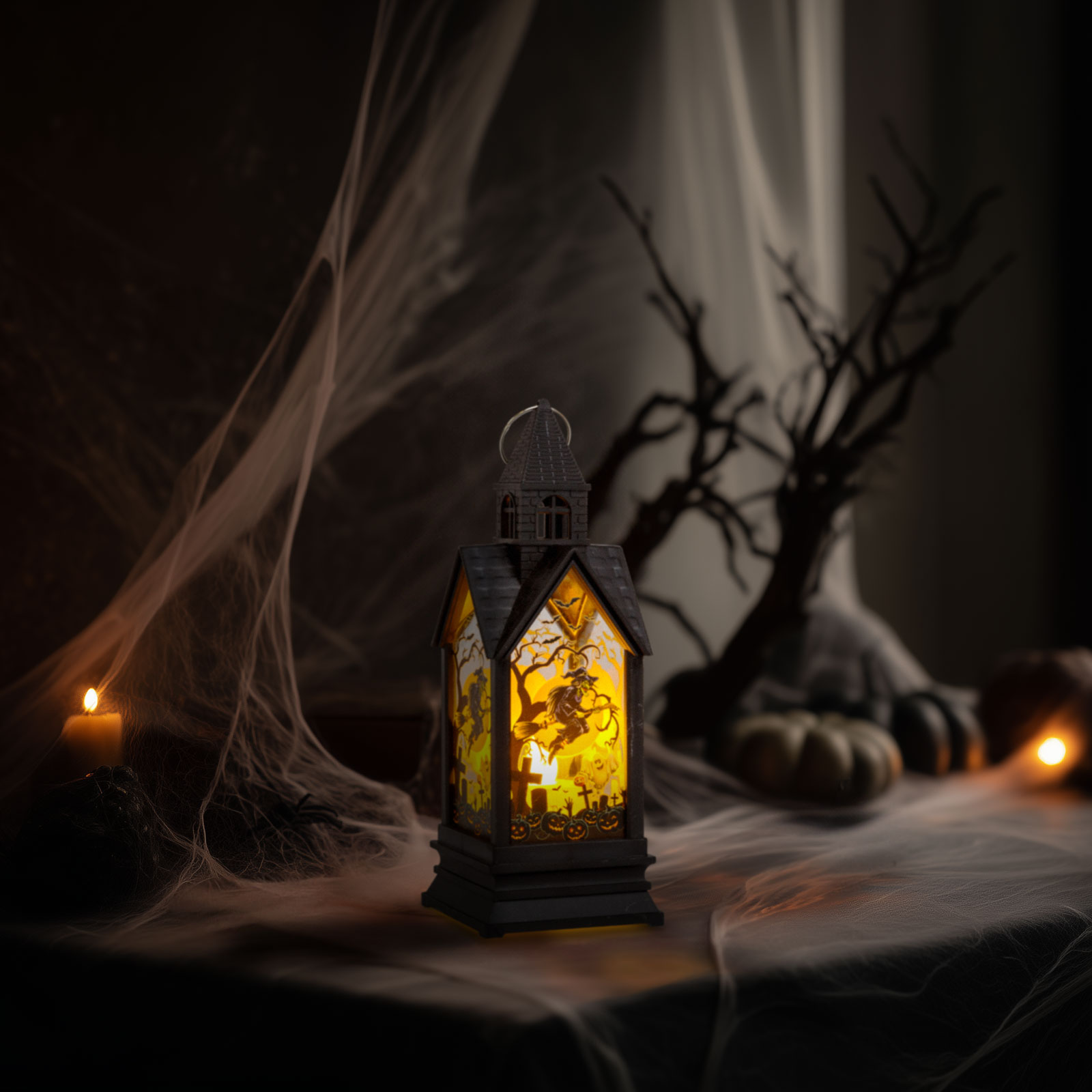 Halloween-i lámpás temető jelenettel. A háttér pókhálót, tököket és egy fa sziluettjét tartalmazza.