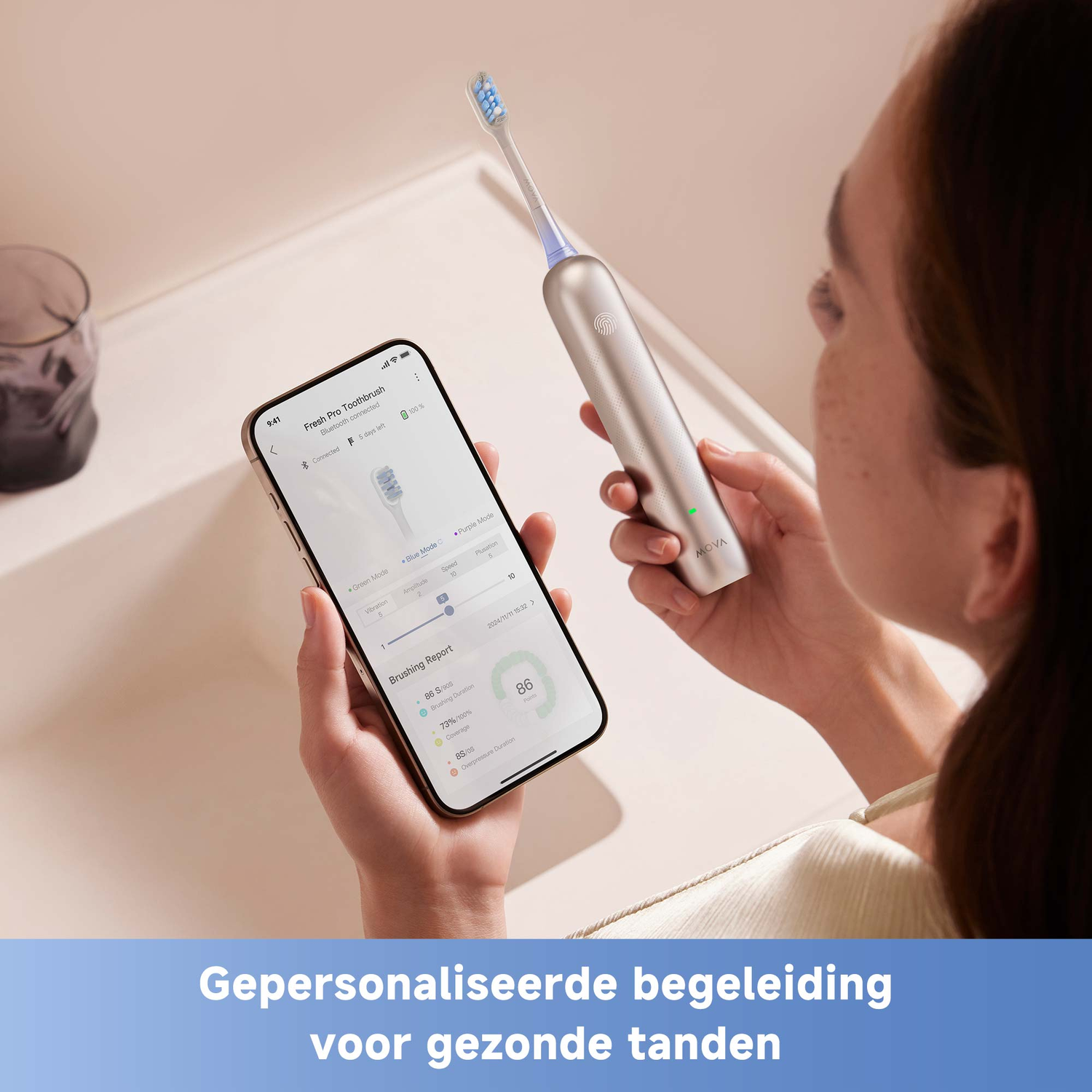 A person holds a toothbrush and a phone showing brushing data. The toothbrush is silver, the phone has an app interface.